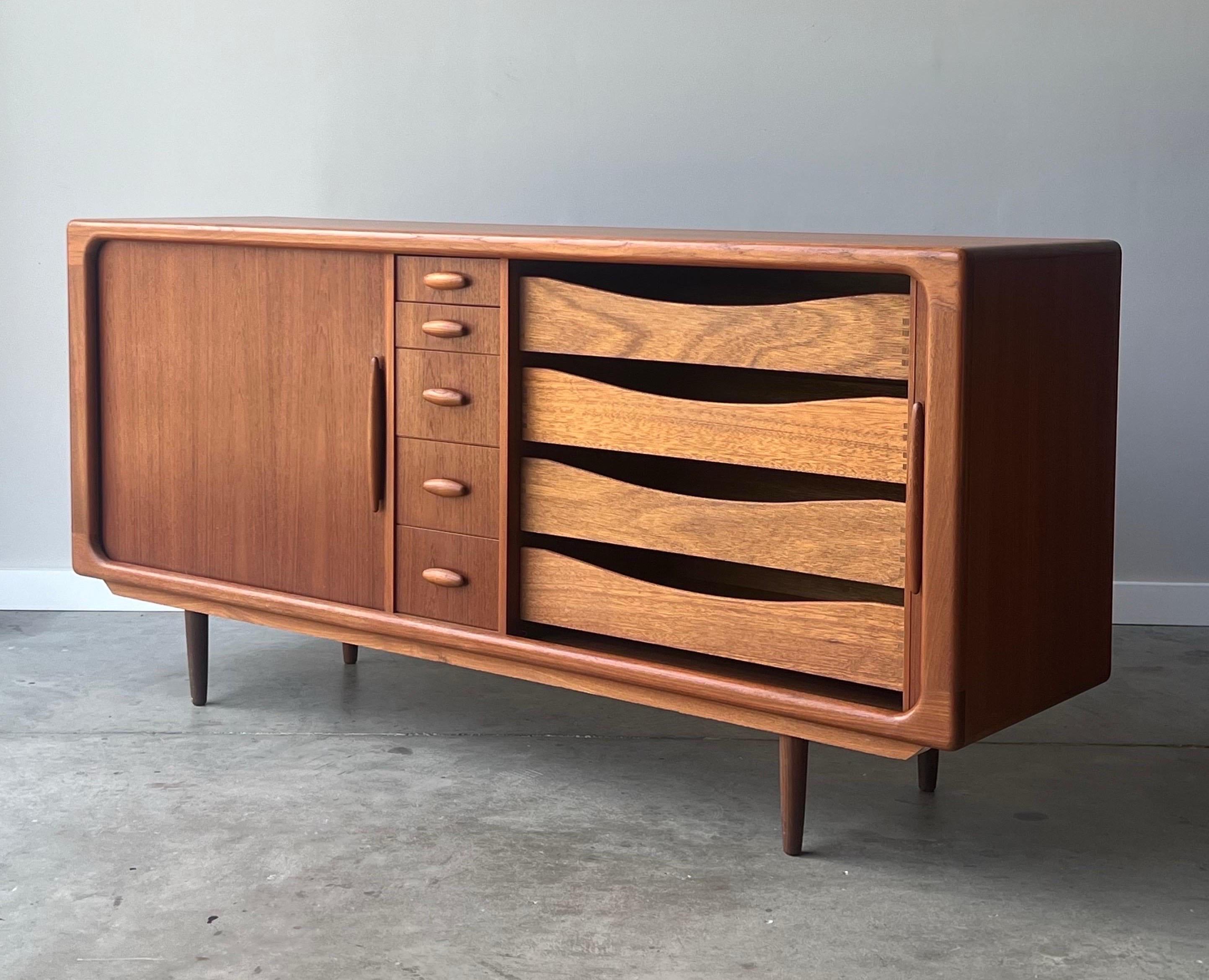 Elegant and stately case piece made by Dyrlund, Denmark. Made from Danish teak wood, circa 1970s. This piece could be used as a traditional dresser, sideboard, or living room credenza as it is both aesthetically and functionally versatile. Tambour