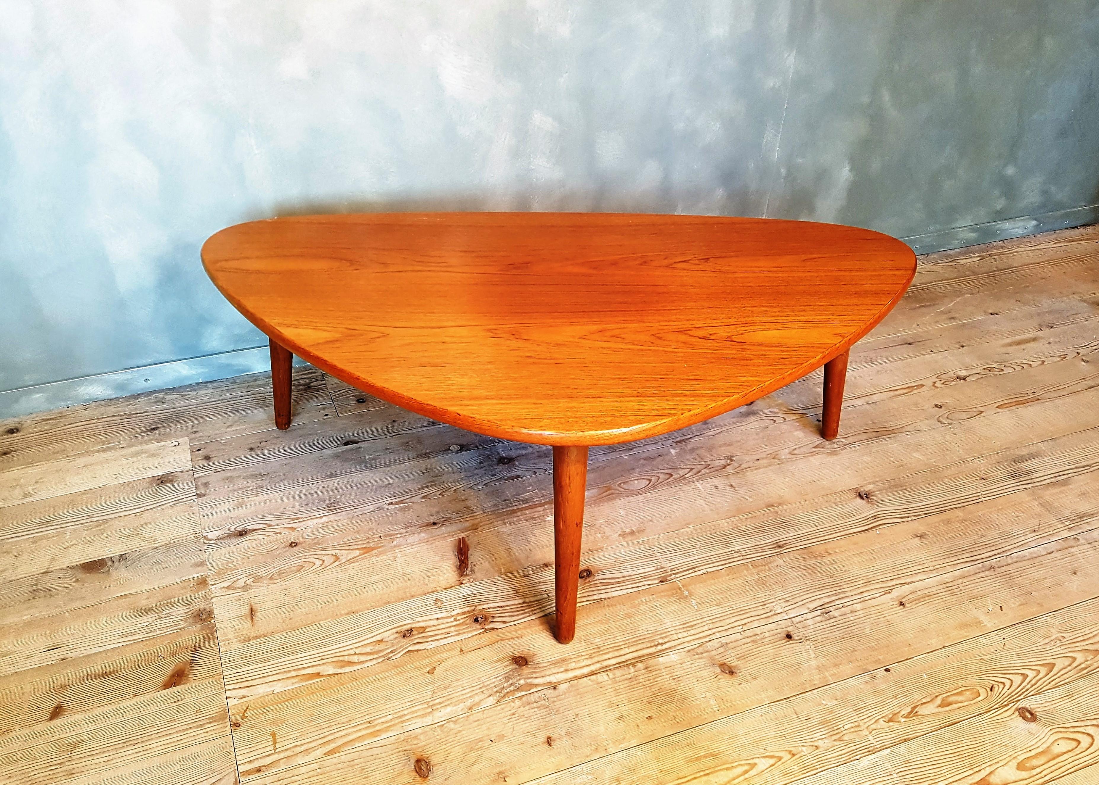 This large and robust Danish coffee table is made from teak and oak with three conical legs. It is in very good original condition.