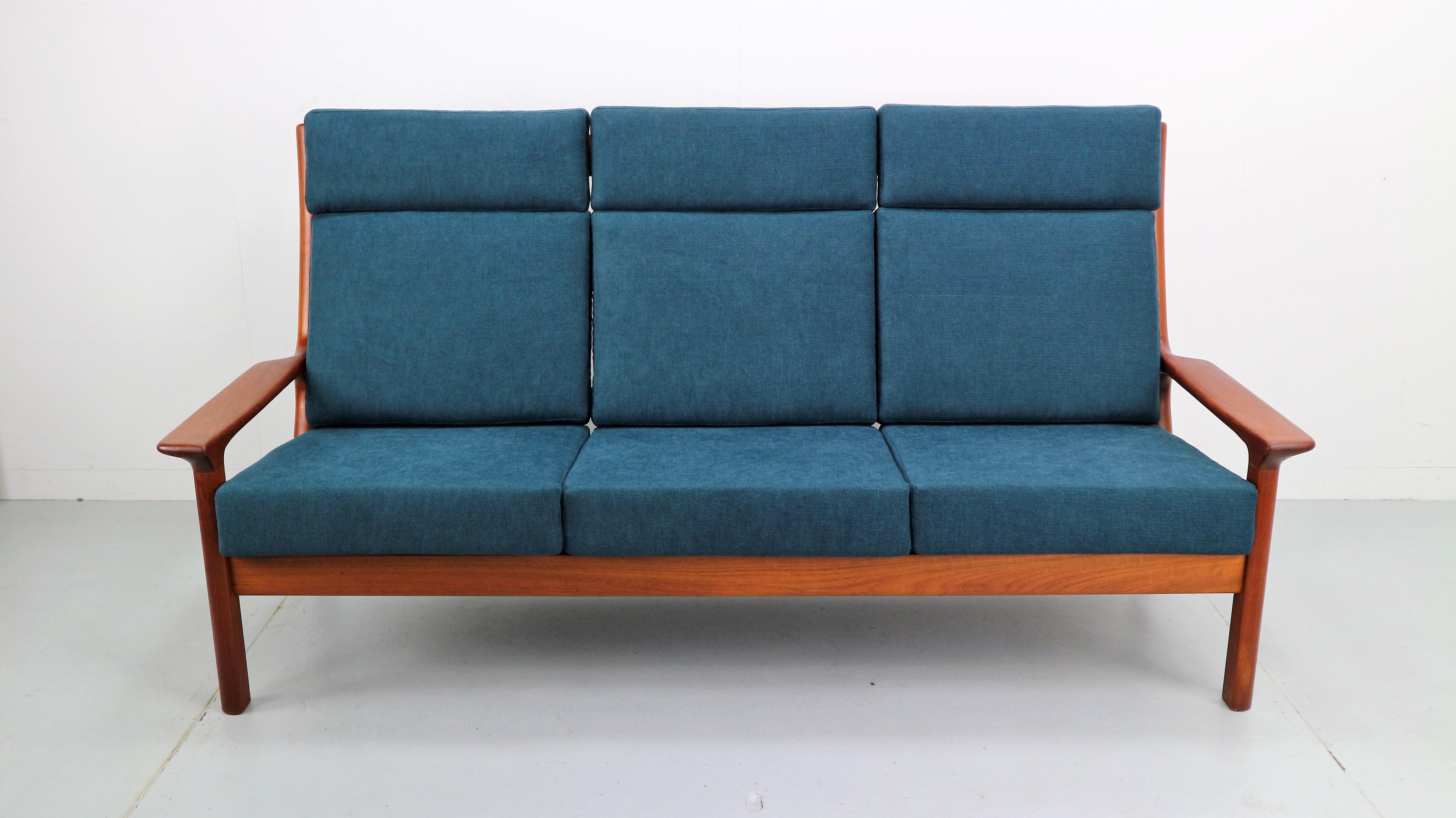 This 3-seat sofa in solid teak was designed by the Danish designer Juul Kristensen and manufactured by Glostrup in the 1960s. The new cushions are newly upholstered in dark blue marine and fitted with zips. This is the more rare high-back seater