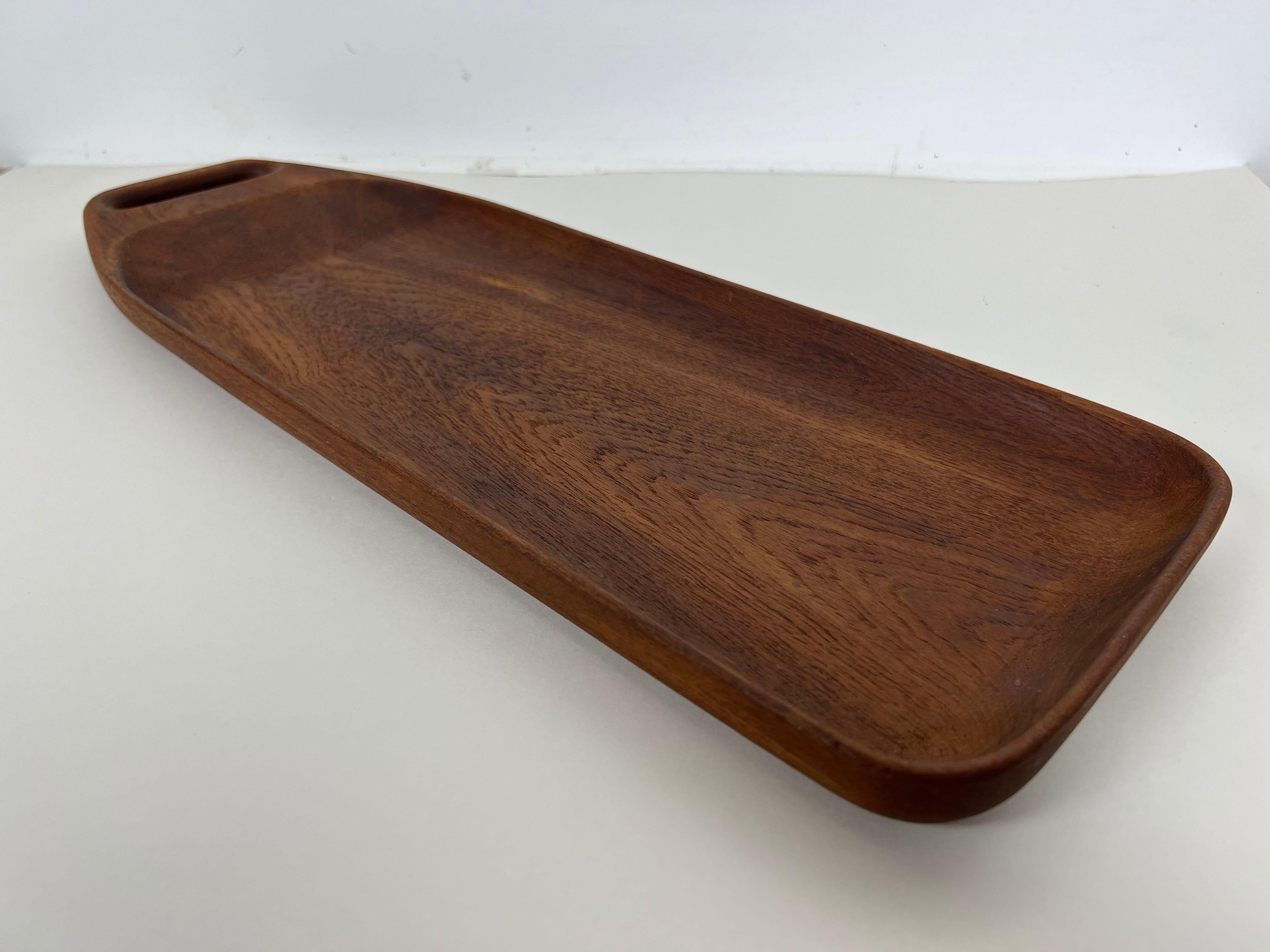 Are vintage Danish serving tray with a beautifully sculpted form and single handle made from solid teak for Bonniers NYC.

Year: 1960s

Origin: Denmark

Dimensions: 19.5