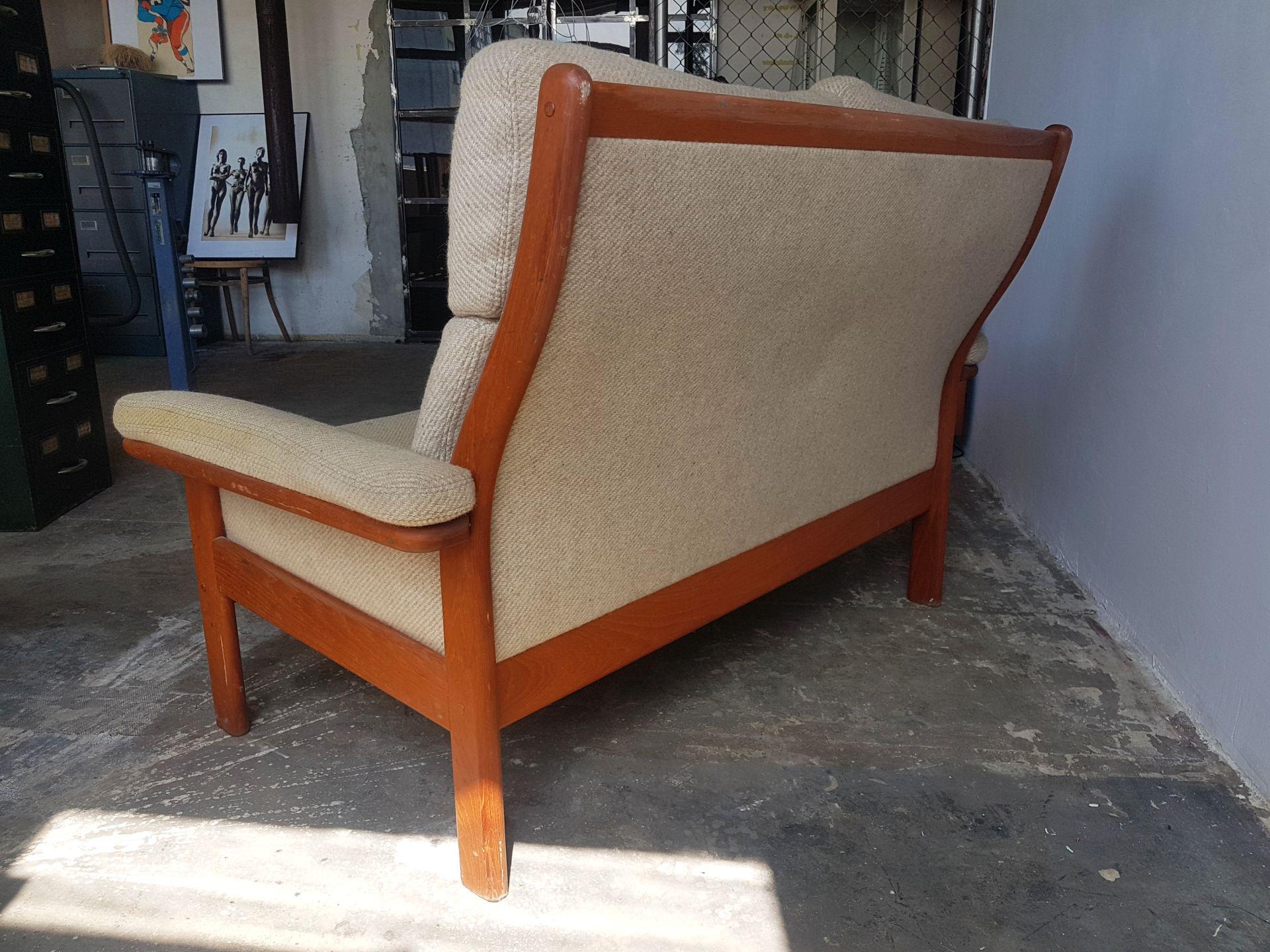 This comfortable two-seat sofa has a frame in solid teak and thick wool upholstery.