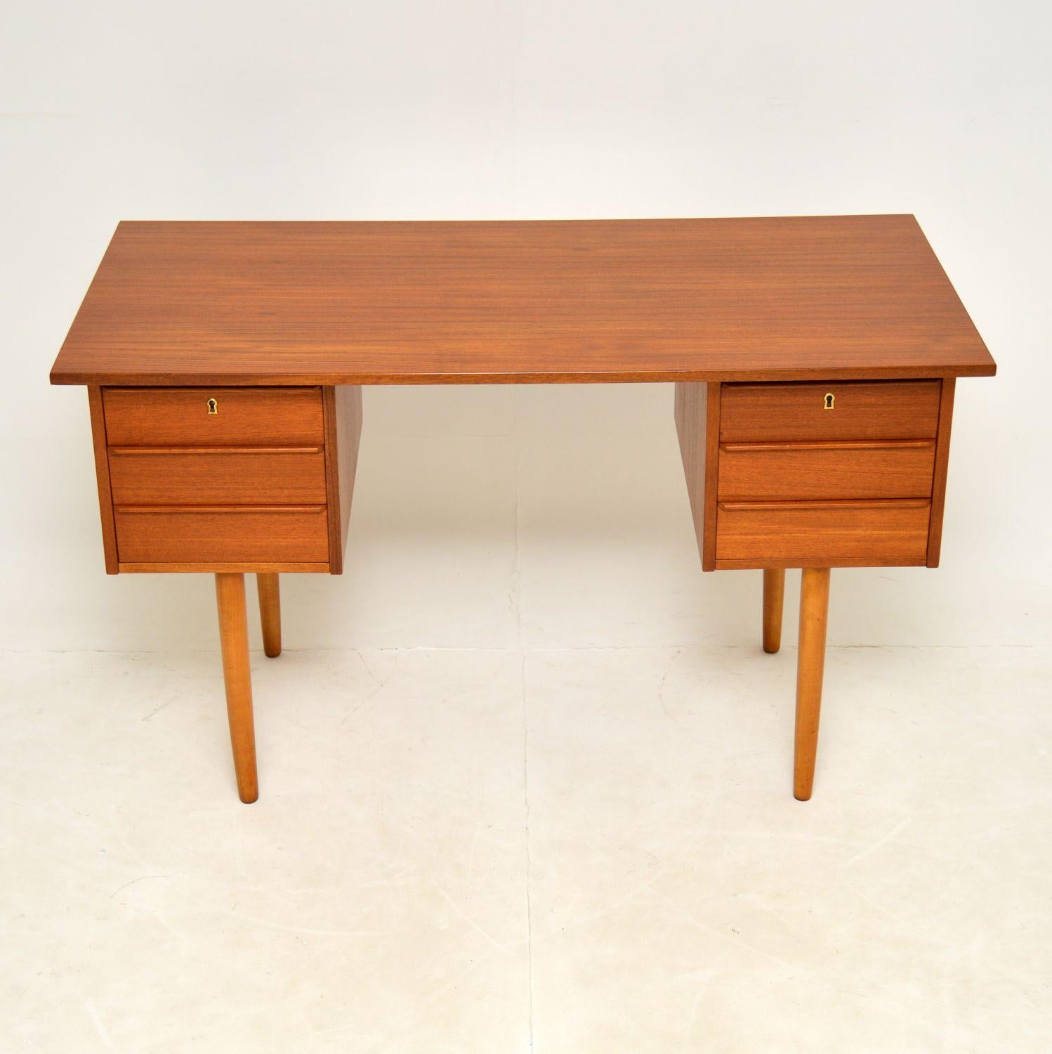 A stylish and very well made vintage desk in teak. This was made in Denmark, it dates from the 1960’s.

It is a lovely compact size, with a beautiful minimal design. The drawers have lipped handles, the desk sits on beautifully tapered legs, and