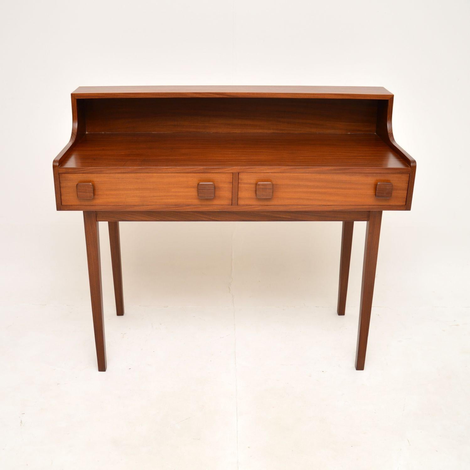 A stylish and very well made Danish teak vintage desk / writing table. This was made in Denmark, it dates from the 1960’s.

The quality is superb, this is beautifully constructed and designed, looking great from all angles. There is a useful back