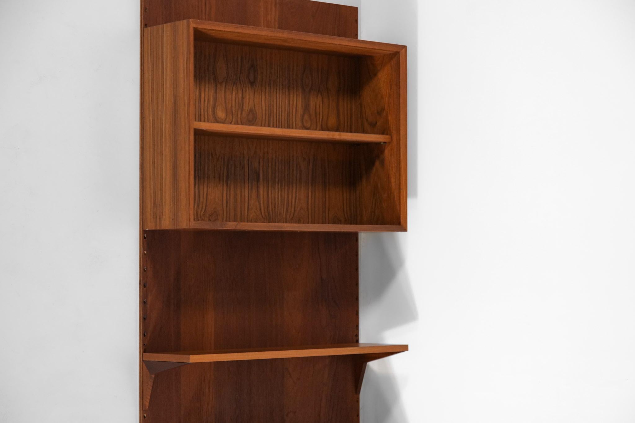 Wall bookcase from the 1960s by Poul Cadovius. This Danish bookcase is composed of different modular elements, the configuration of the shelves and the display case can be changed according to your needs. Solid teak and veneer structure. Very nice