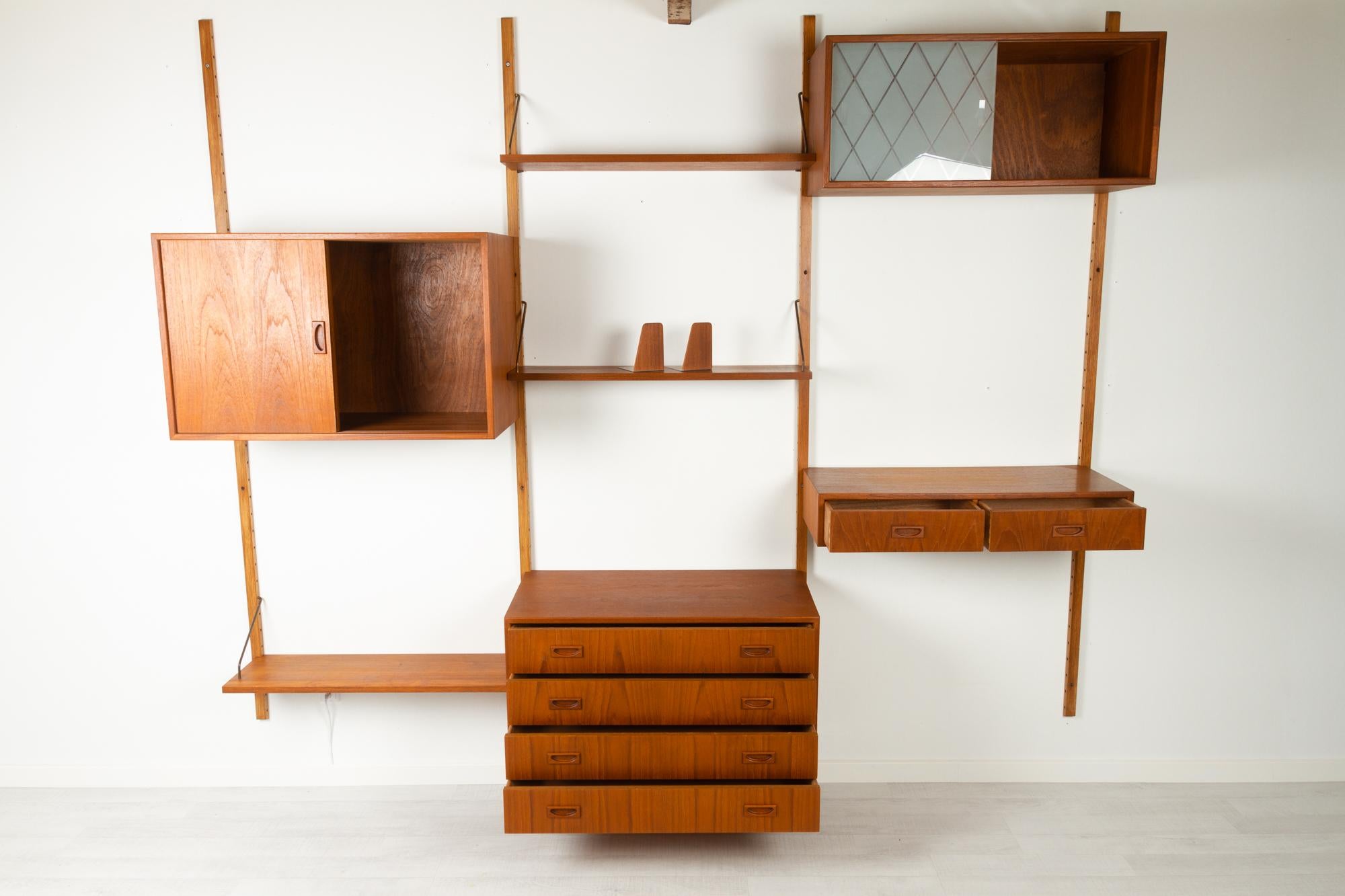 Danish teak modular wall unit by Preben Sørensen for PS System Randers, Denmark 1960s.
Danish mid-century modern three bay wall mounted shelving unit in teak. 

This set consists of the following elements:
- 4 Uprights in stained beech, length: