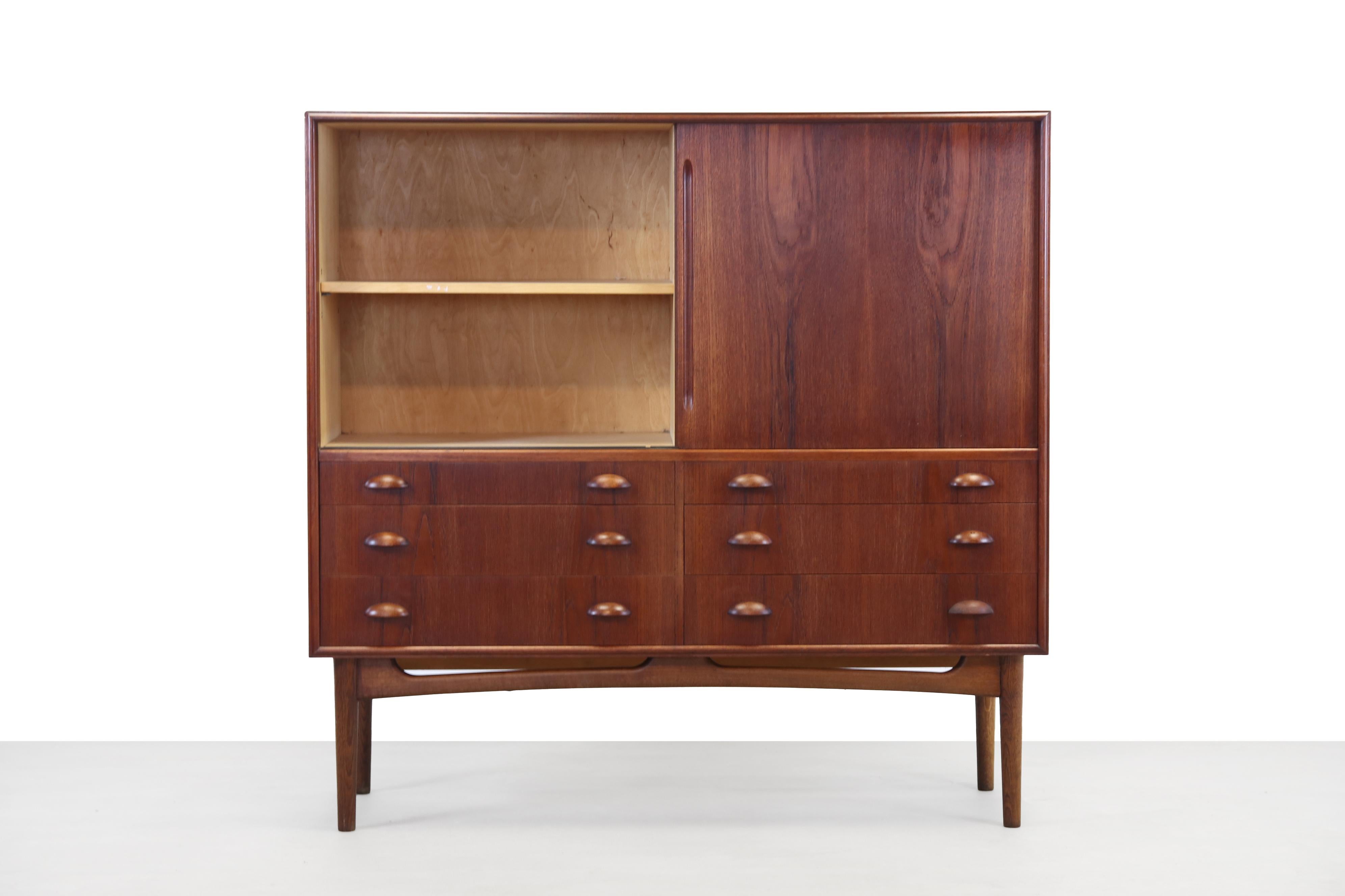 Very fine sized teak Danish design highboard. This cabinet has a teak exterior, a birch interior and an oak wooden base. Over time, the oak has been colored almost the same as the teak of the cabinet. The cabinet has two sliding doors and six