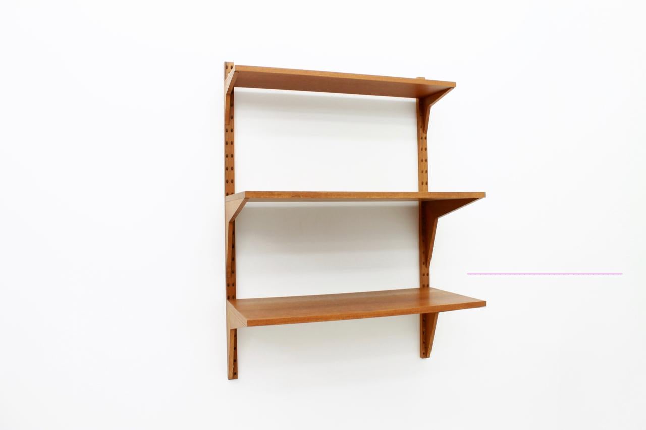 Small wall system by Poul Cadovius for Cado Denmark with three shelves and two wall holder. Very good condition.