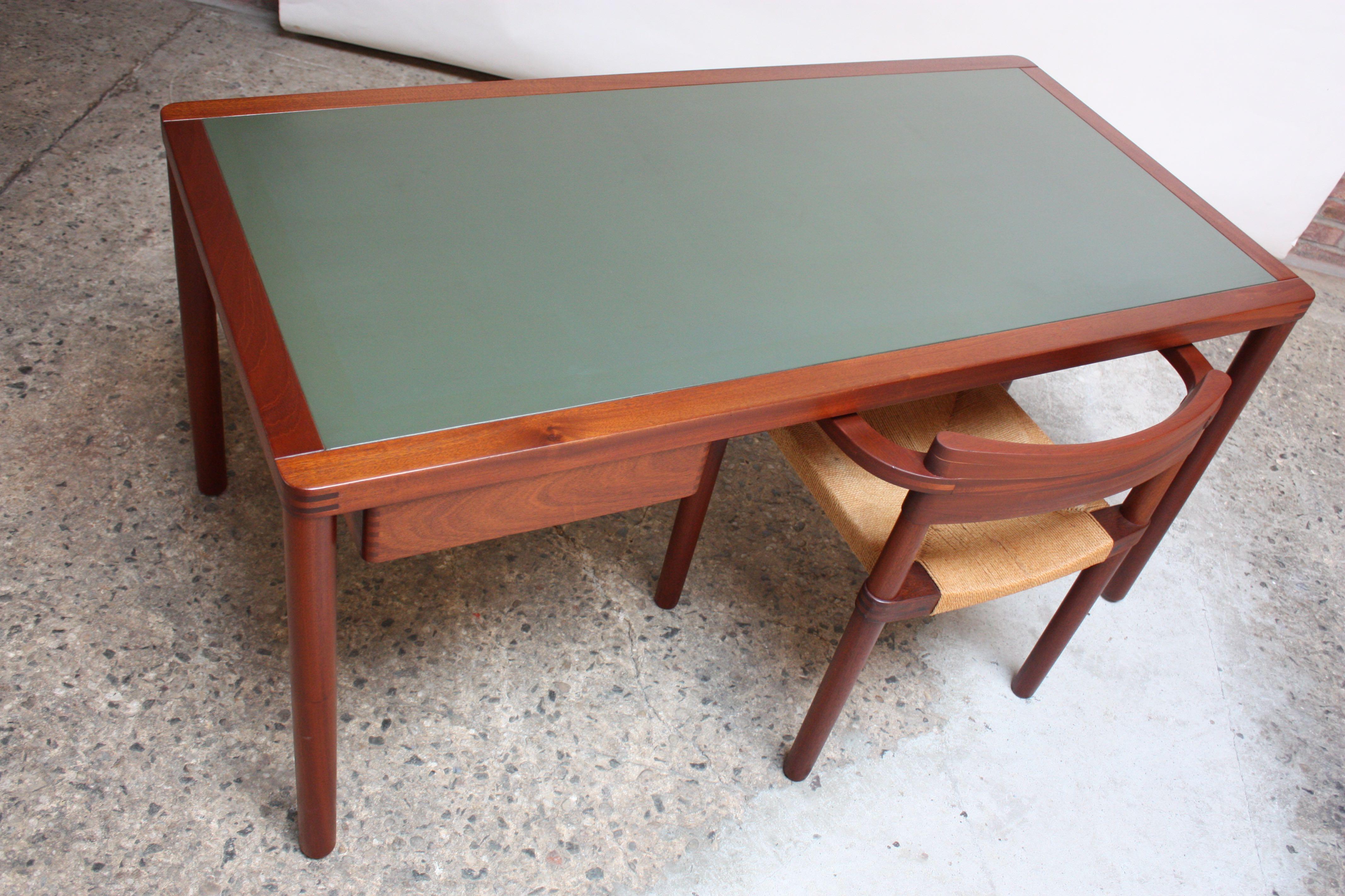 Handsome Danish modern teak desk with nice dovetail and other wood joinery details and rich wood grain. Original green laminate surface is in nice, vintage shape with light wear (small rings and few spots of discoloration). Single drawer, which