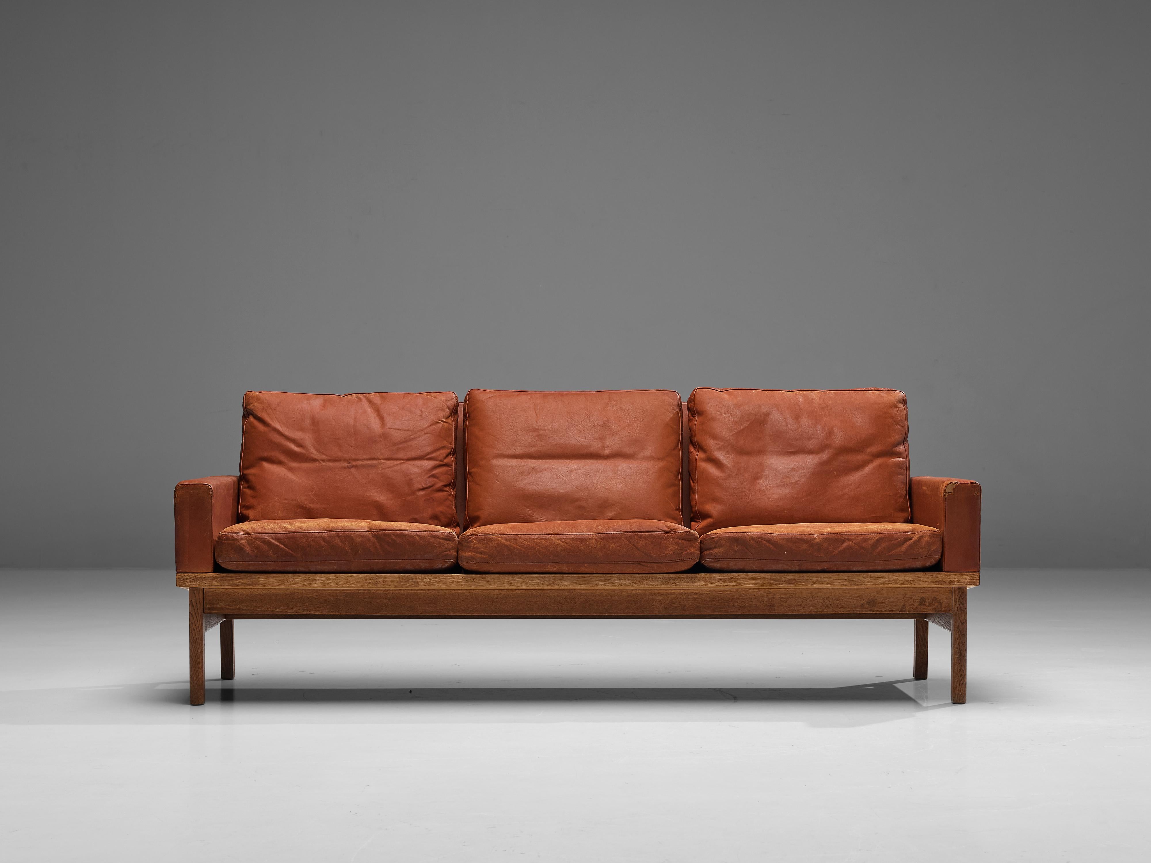 Sofa, leather, oak, Denmark, 1960s 

This classic sofa of Danish origin features modest and subtle lines and shapes that emphasize the clear construction of the design. A nice detail is how the back elegantly runs over into the armrests, developing