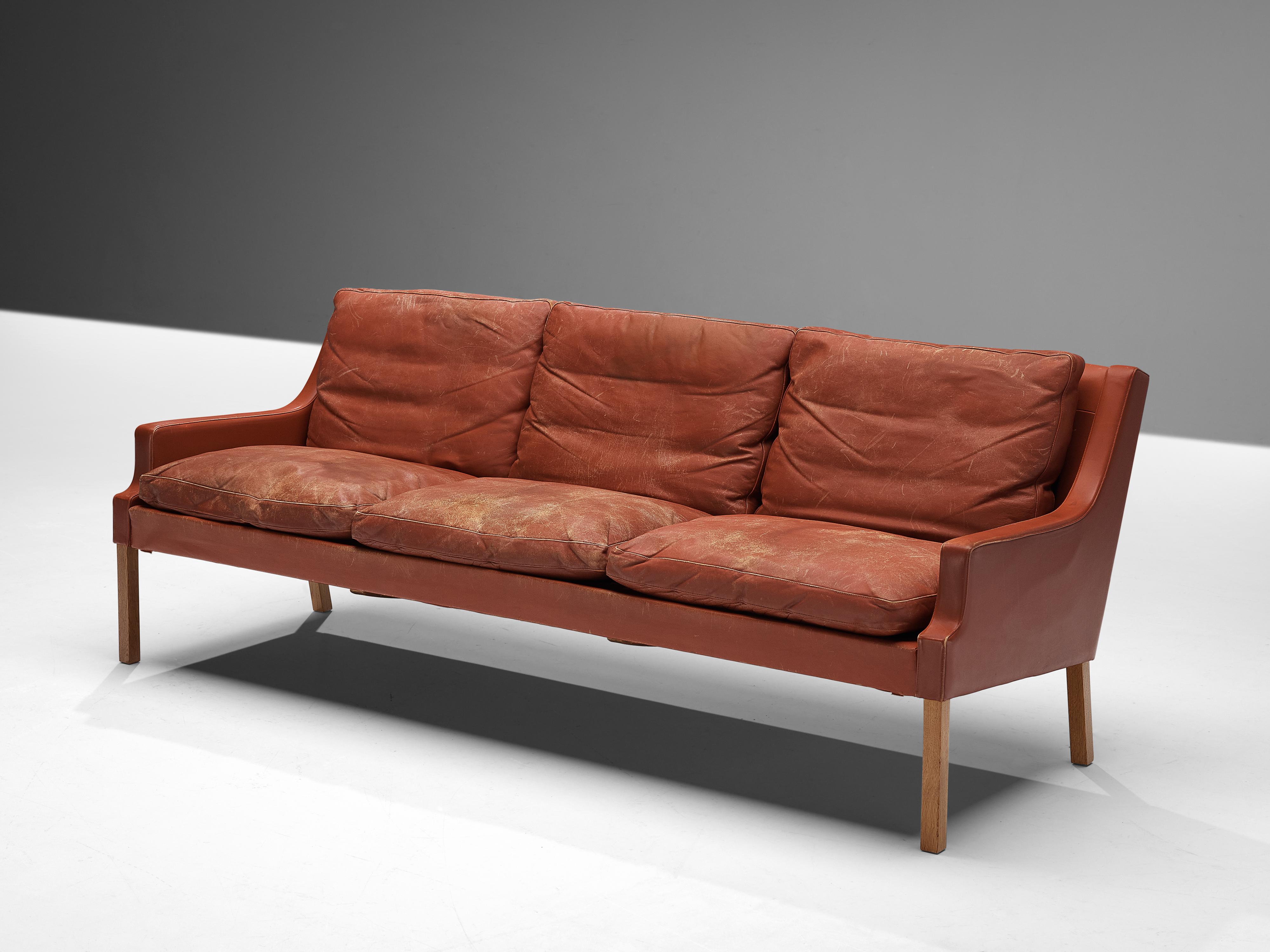 Sofa, leather, oak, Denmark, 1960s 

This classic sofa of Danish origin features modest and subtle lines and shapes that emphasize the clear construction of the design. A nice detail is how the back elegantly runs over into the armrests, developing