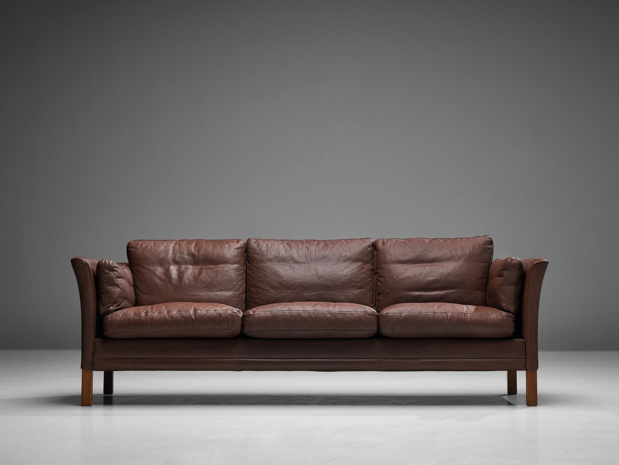 Sofa, leather, wood, Denmark, 1960s

This model reminds of Borge Mogensen's designs. The umber brown leather shows a light patina and is in great condition. The dawn-filled cushions create a comfortable seat. Three seats offer plenty of place to