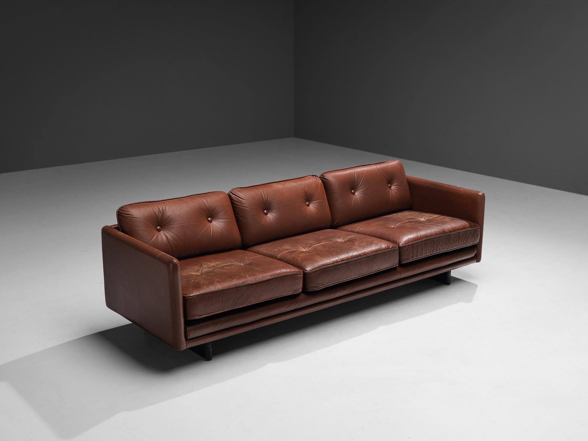 Three seater sofa, leather, wood, Scandinavia, 1960s.

This comfortable three seater sofa holds a robust, sturdy character. The solid sled base is made of black lacquered oak. The sofa itself is executed in a thick, high-quality chestnut brown
