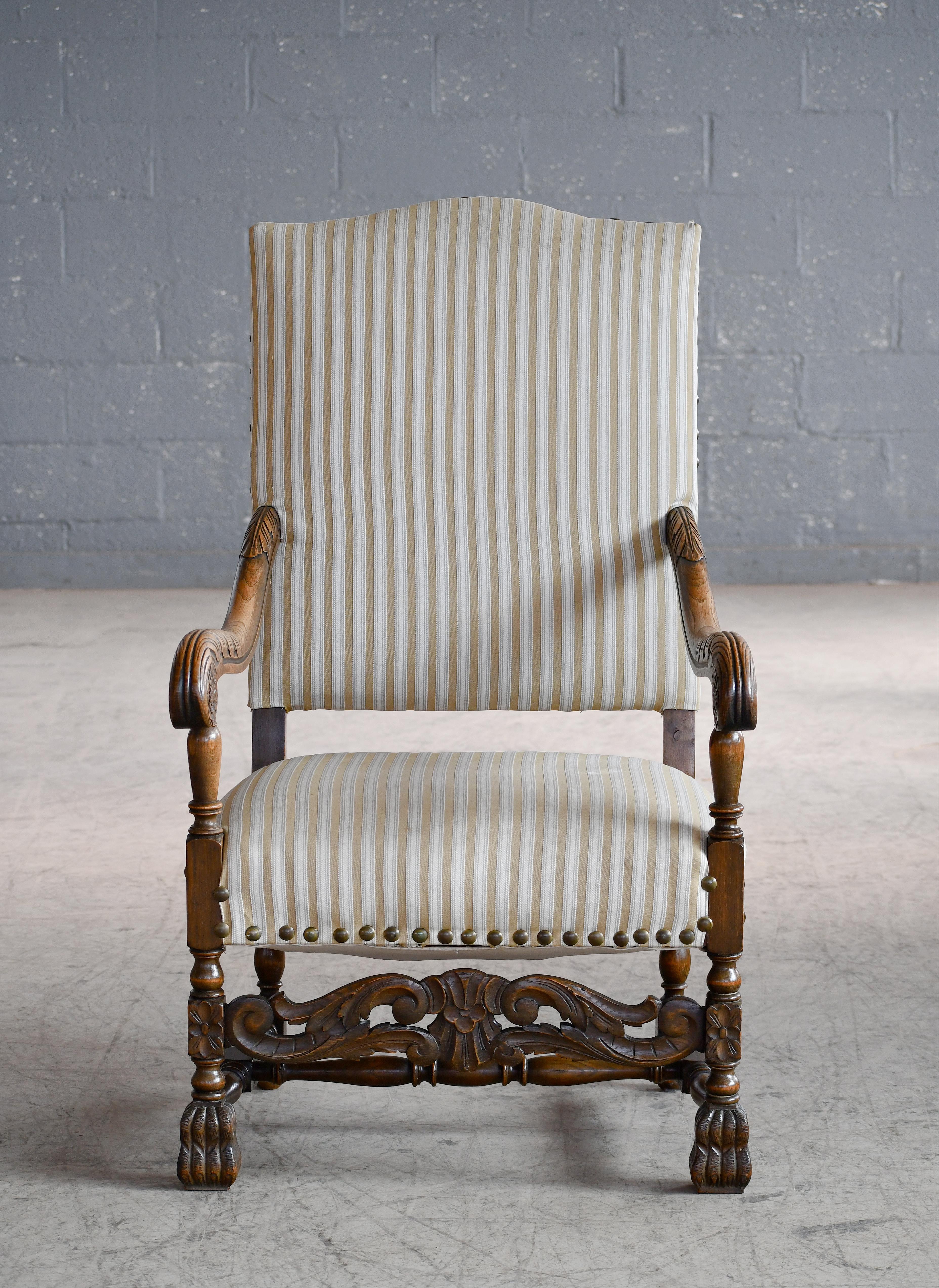 Beautiful carved oak throne chair made in Denmark, circa 1900. Solid and Sturdy. Re-upholstered at a later date and fabric in good clean usable condition. Solid and sturdy and overall very good condition with nice wear and patina to the armrests.