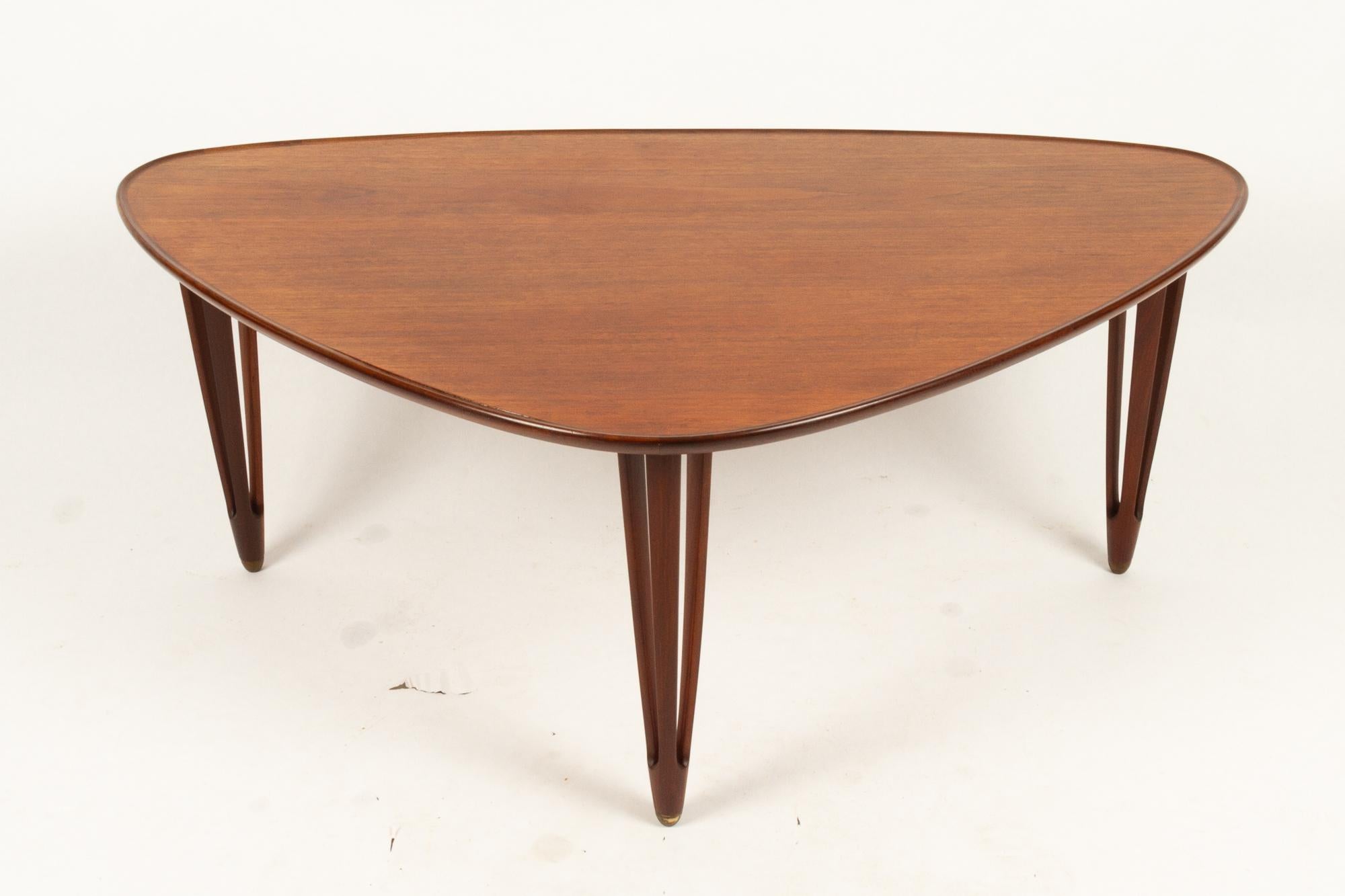 Danish triangular teak coffee table 1950s
Very stylish Mid-Century Modern coffee table with three split legs. Organic triangular shape with rounded corners. Carved legs in solid teak. Raised edge also in solid teak. Beautiful craftsmanship.
Marked