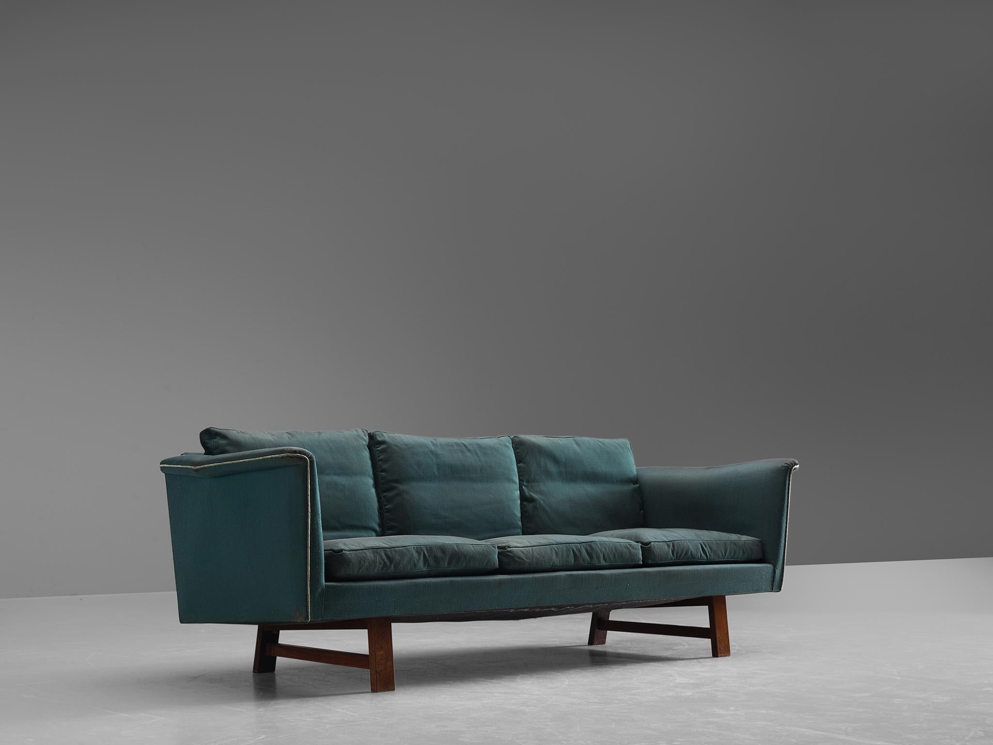 Three-seat sofa, fabric and wood, Denmark, 1950s.

This comfortable sofa has a sturdy appearance, with elegant armrests that flow outwards. The horizontal character is emphasized by the geometric wooden frame that matches wonderfully with the seat.