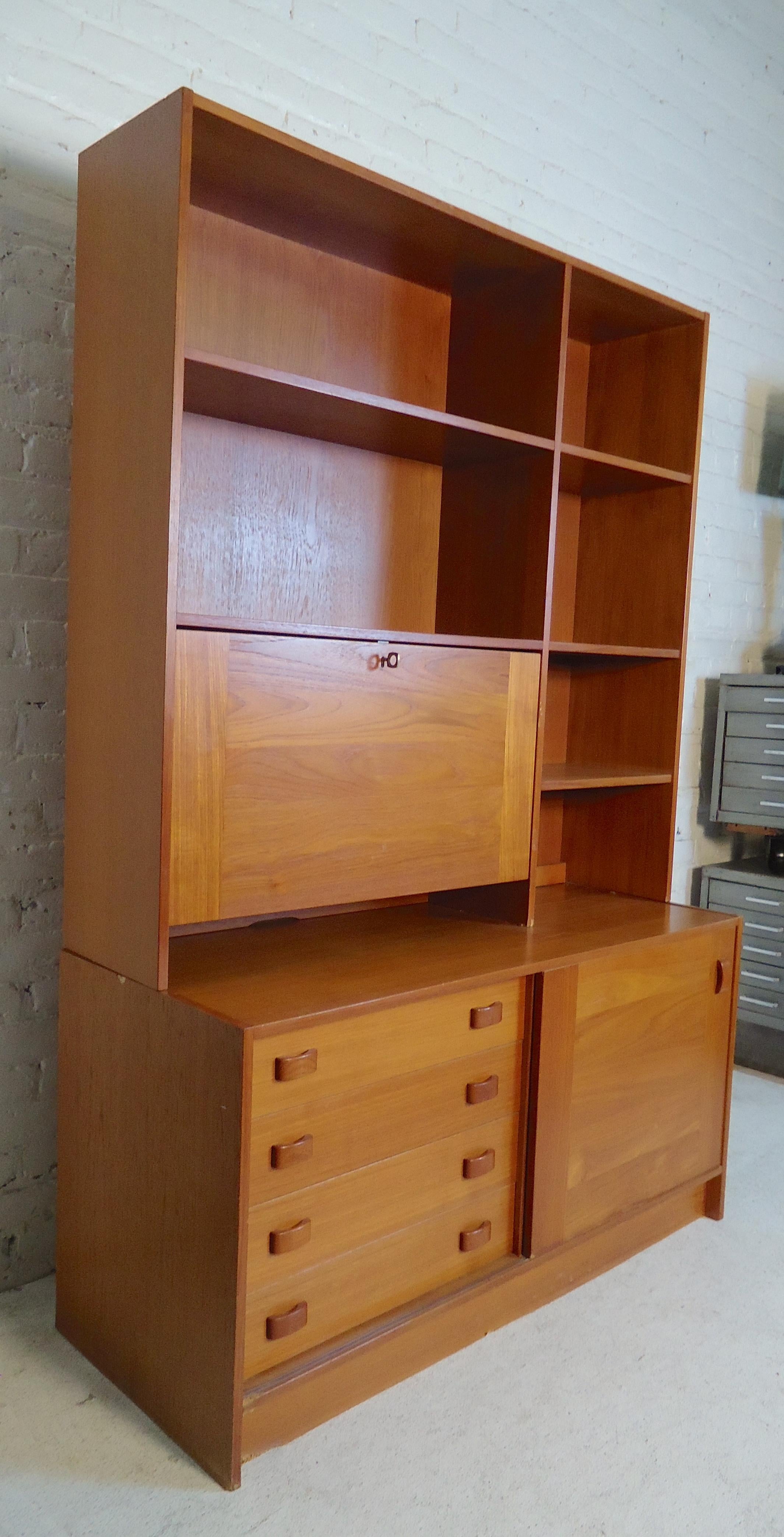 Teak grain cabinet with bookcase topper. Features ample storage with drawers, shelving, pull down cabinet and sliding door cabinet.
(Please confirm item location - NY or NJ - with dealer).
 