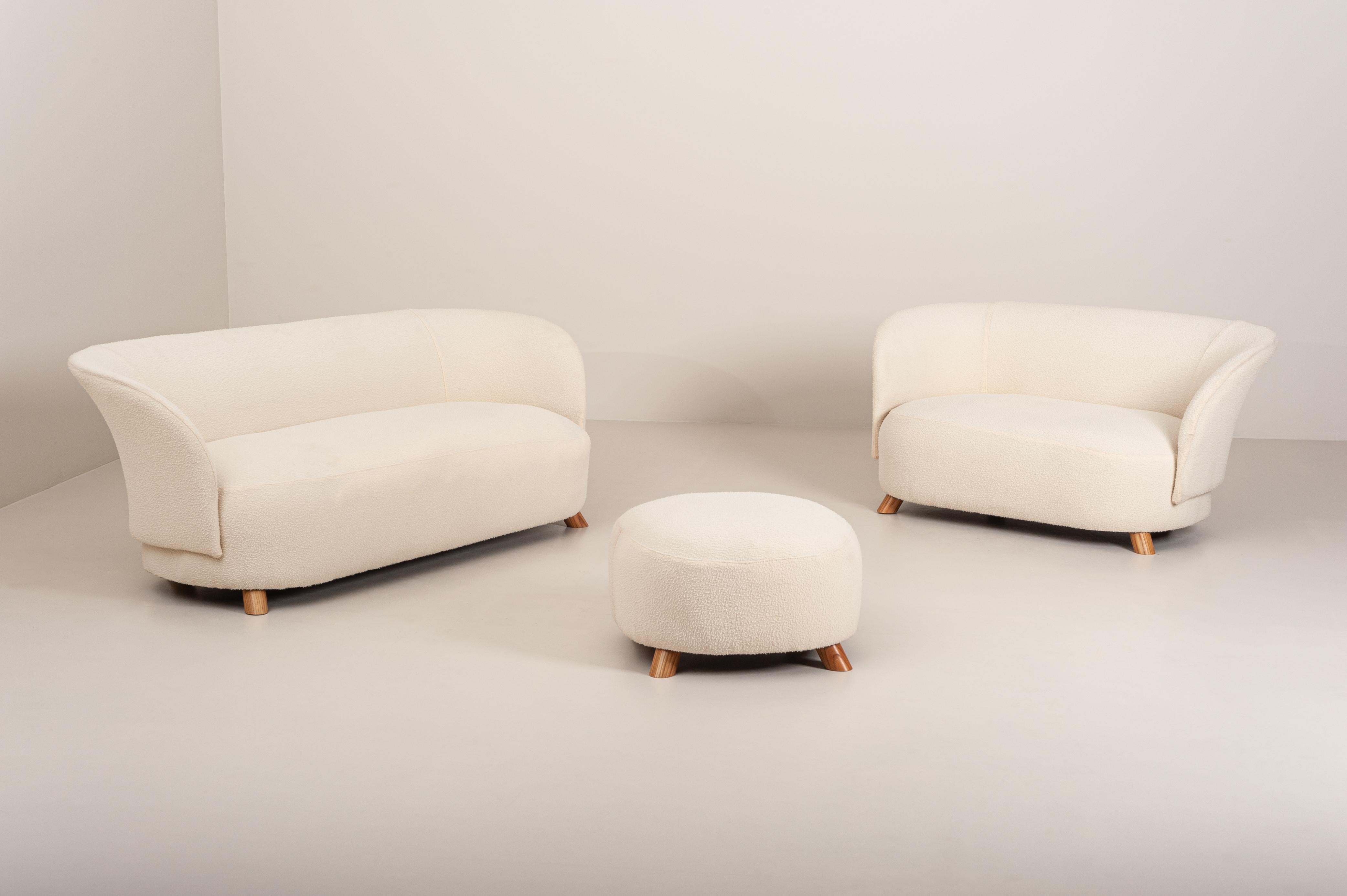 Dieses schöne und stilvolle Zweisitzer-Sofa ist Teil eines Wohnzimmersets, das aus einem Dreisitzer-Sofa und einem großen Hocker besteht. Es wurde in den 1940er Jahren in Dänemark entworfen und hergestellt. 
Er ist in ausgezeichnetem Zustand: