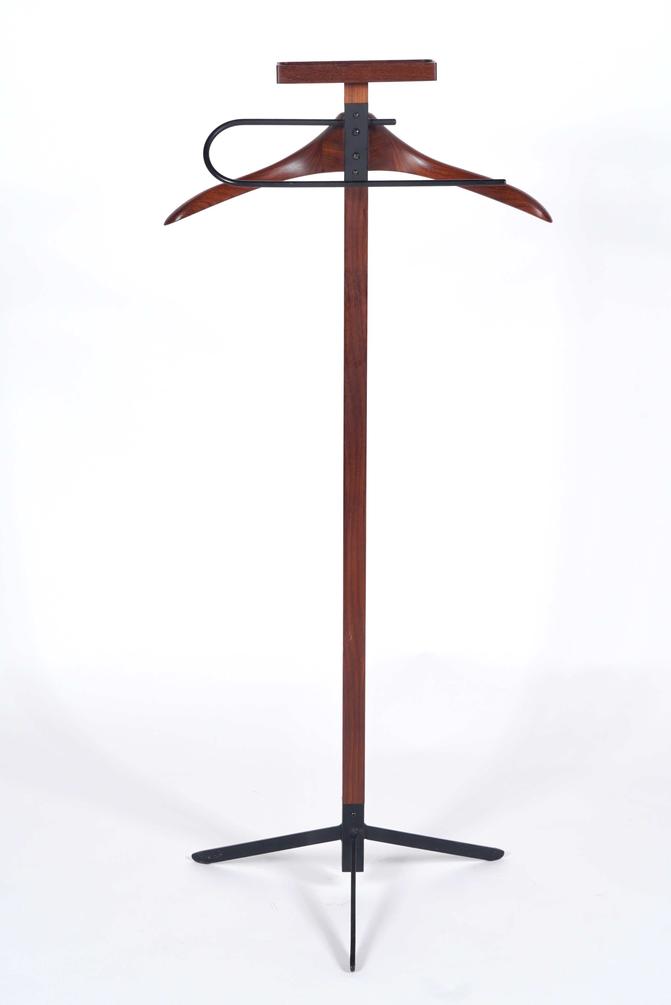 Danish teak valet, designed to hold a suit, watches, loose coins etc. A sculptural piece that incorporates wood and metal into a sleek modernist design, resting on a tripod base. Stamped 
