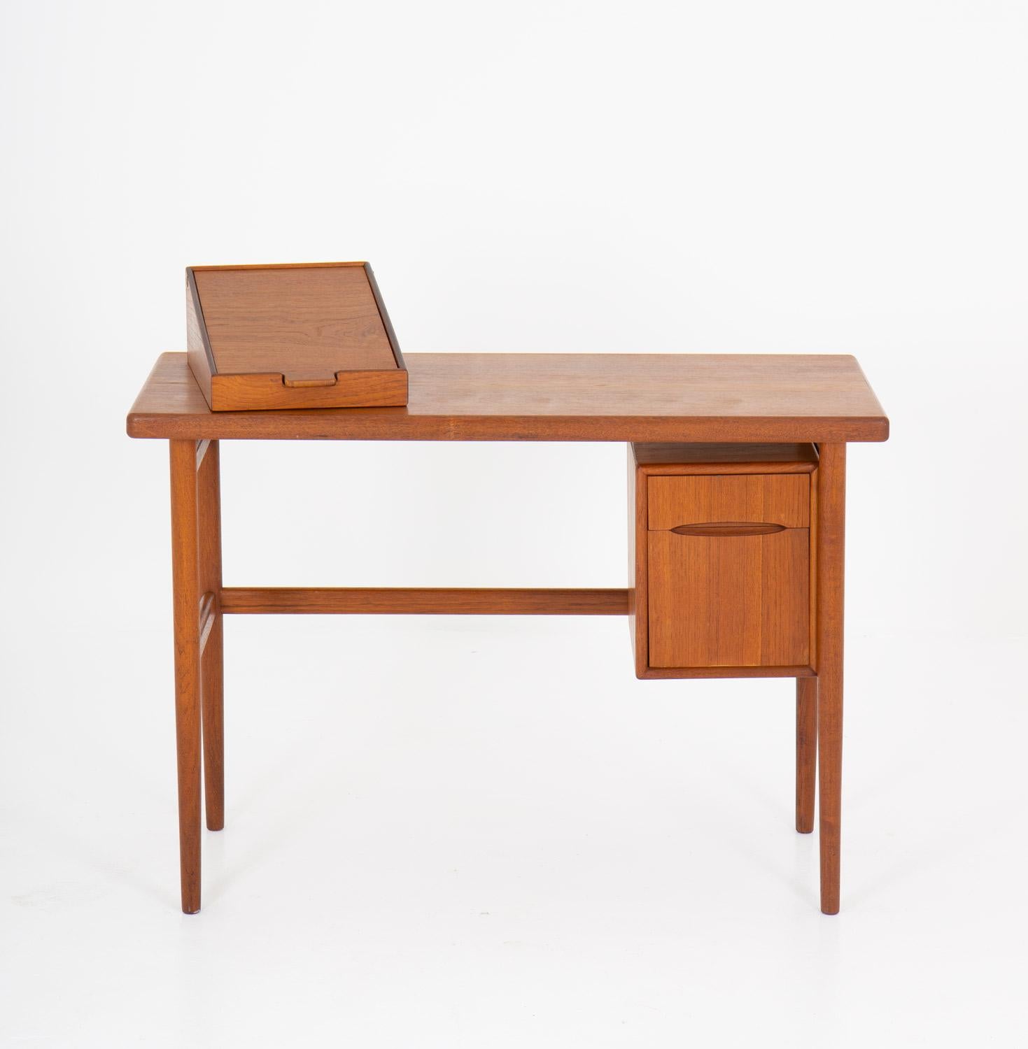 Bureau ou coiffeuse en teck de Kurt Østervig, Danemark, années 1950.
Petit bureau avec des détails intéressants. Les tiroirs sont dotés de belles poignées sculptées. Sur le plateau de la table se trouve une boîte à bijoux avec un miroir pliable qui