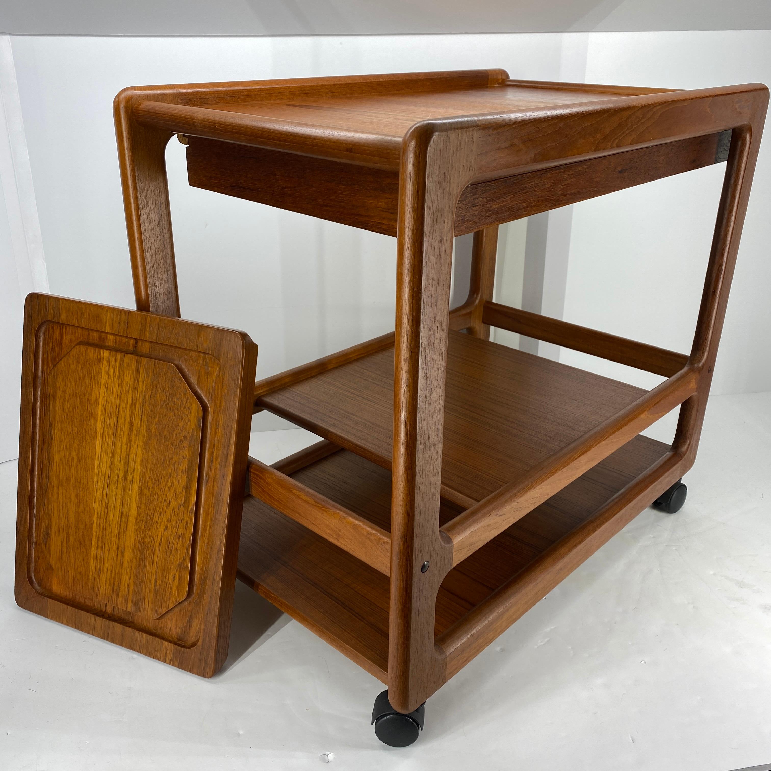Mid-Century Modern teak bar trolley or serving cart by Vildbjerg Mobelfabrik
Just look at this all teak bar cart serving trolley. Three tiers all glowing with beautiful wood grain. There is a single drawer that can be either tucked away or easily