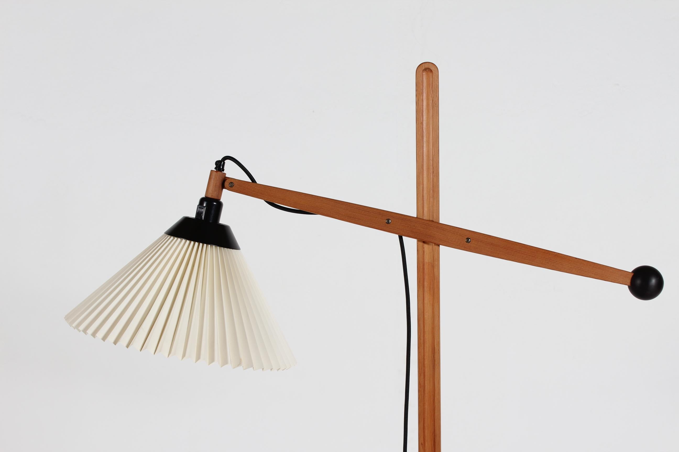 Danish Vilhelm Wohlert vintage floor lamp with adjustable arm model no. 325 made for Le Klint in the 1970s. 
The frame is made of origon pine with great patina and the lamp foot of metal with black lacquer. The Lamp comes with an original Le Klint