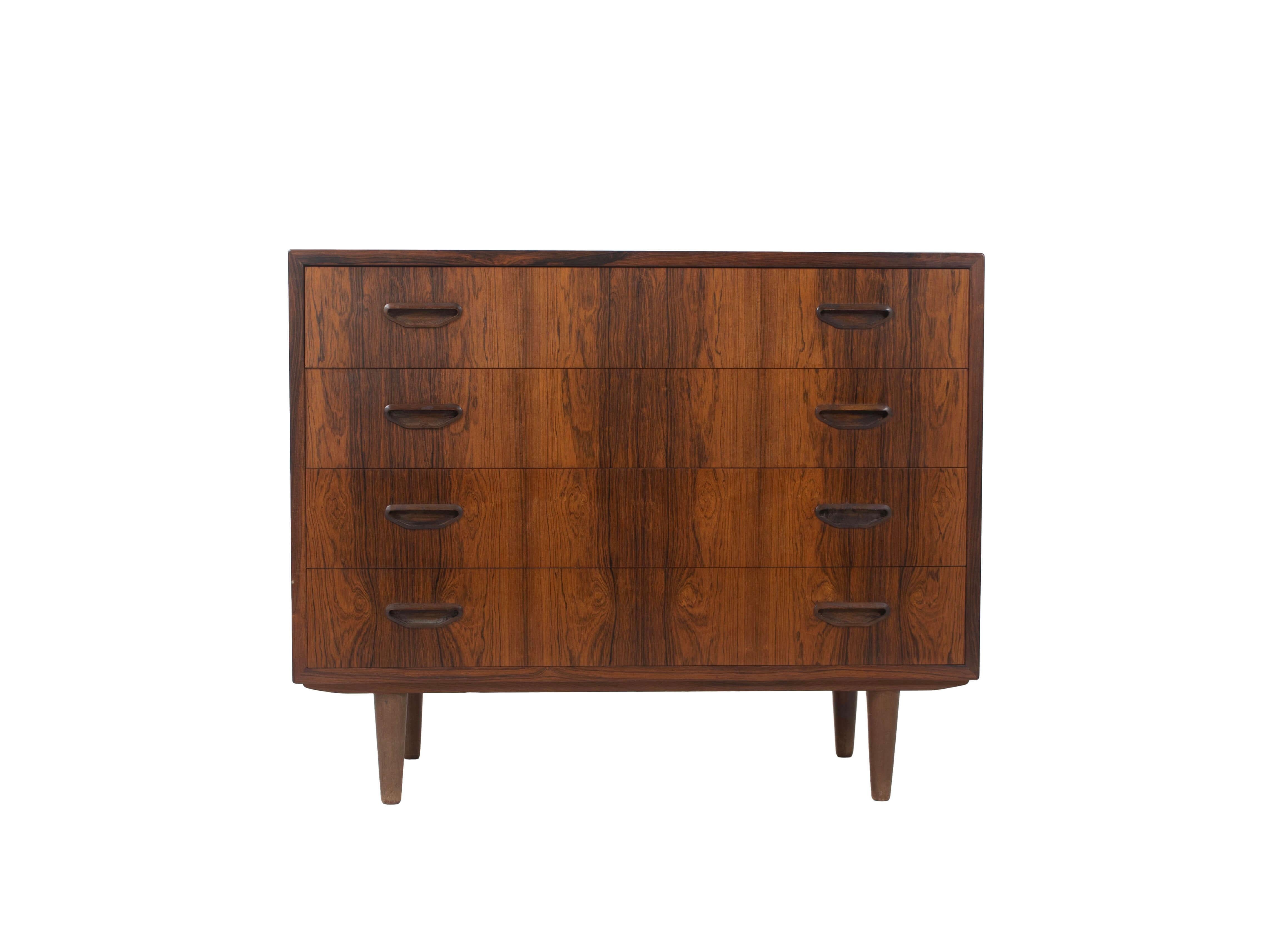 Nice Danish vintage chest of drawers by P. Westergaards Møbelfabrik in Rosewood Veneer from the 1960s. The chest of drawers has four drawers and is fitted with round legs. A very practical yet elegant piece of furniture. This vintage chest of