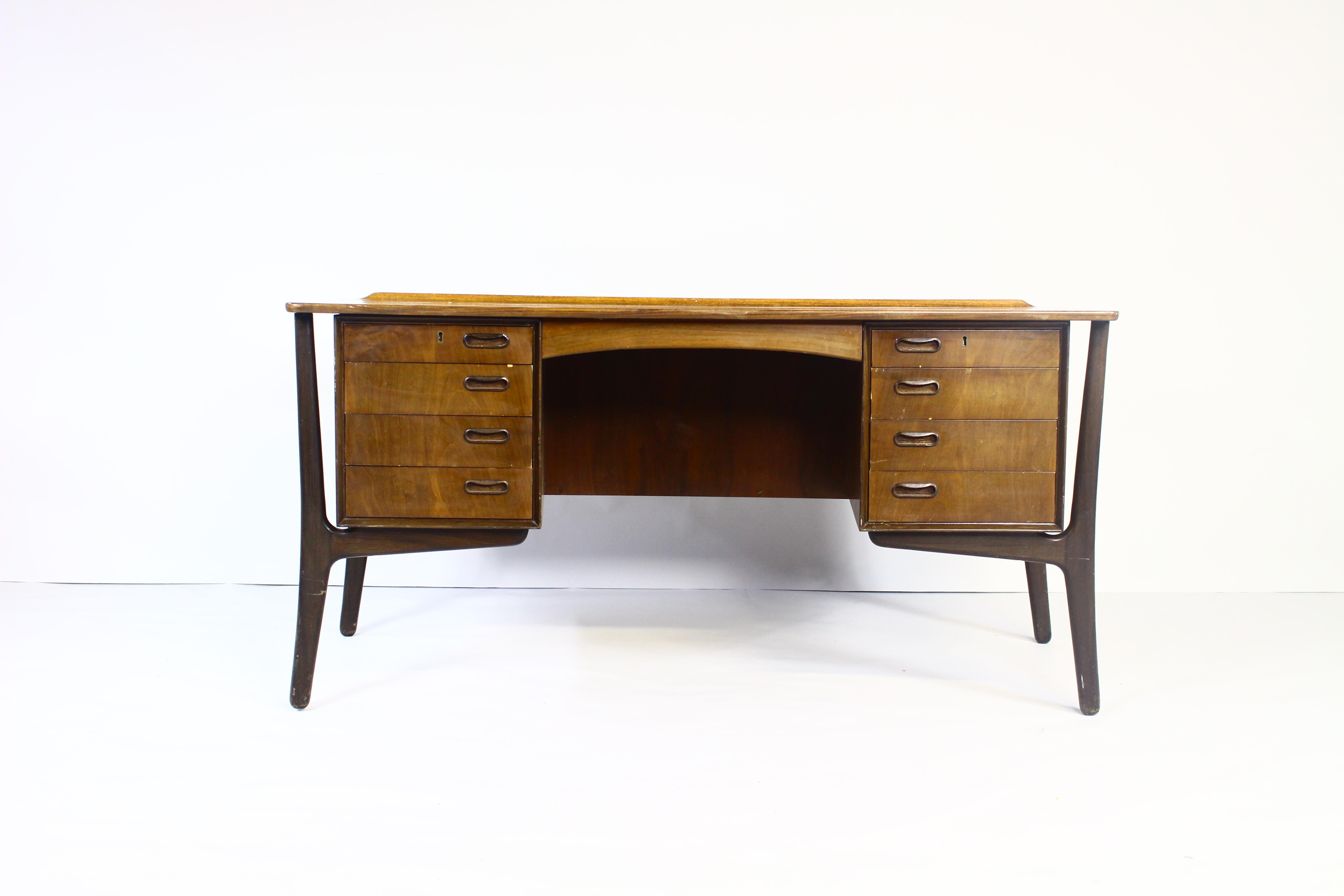 Danish walnut desk with eight-drawers and open shelf at the back on sculpture-like legs,
designed by Svend Aage Madsen.