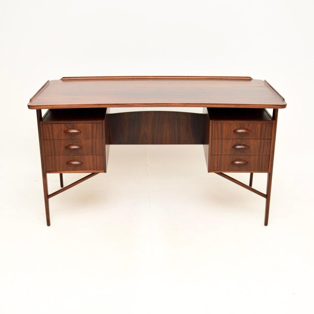 A magnificent Danish vintage desk by Svend Aage Madsen, dating from the 1960’s.

It is of the utmost quality, with a very stylish design and many fine features. The top has a slightly bowed kidney shape, with a raised lipped back and sides. The top