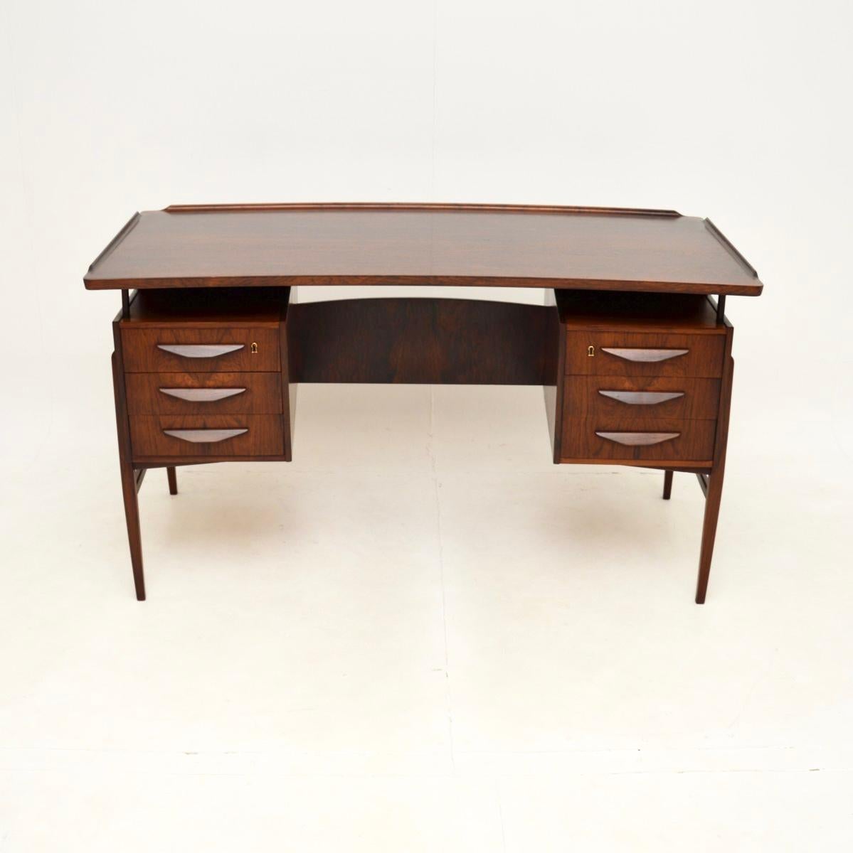 Una magnifica scrivania danese vintage di Svend Aage Madsen, risalente agli anni Sessanta.

È di altissima qualità, con un design molto elegante e molte caratteristiche di pregio. Il top ha una forma a rene leggermente arcuata, con fondo e fasce in