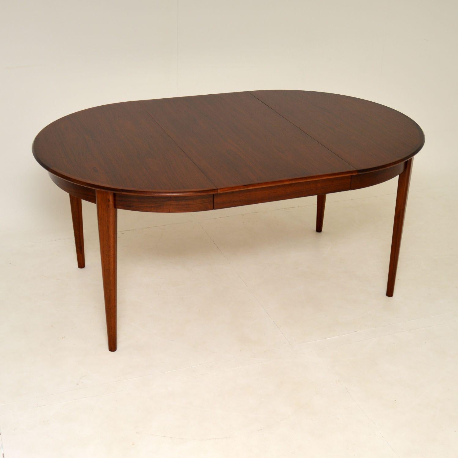 A stunning vintage Danish dining table. This was made in the 1960’s, it is the model 55 table designed by Gunni Omann for Omann Junior Mobelfabrik. It has the Danish quality control stamp below the top.

It is circular when closed, and comes with