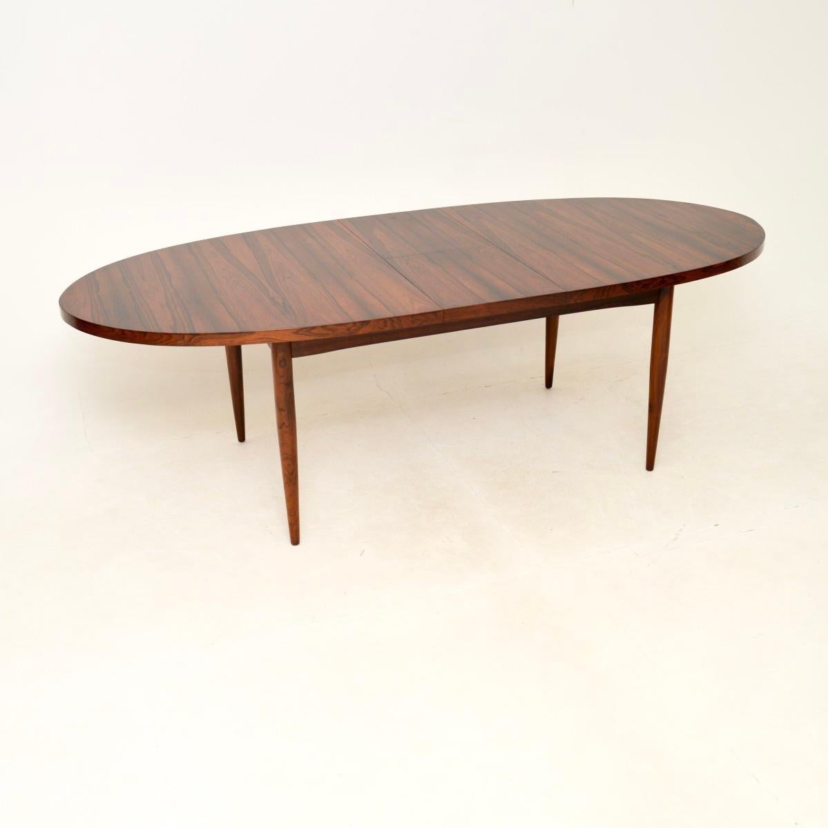 A stunning Danish vintage dining table, dating from the 1960’s.

This is of outstanding quality, with beautiful grain patterns throughout. The oval top slides apart in the middle and an extra leaf can unfold to extend the surface area