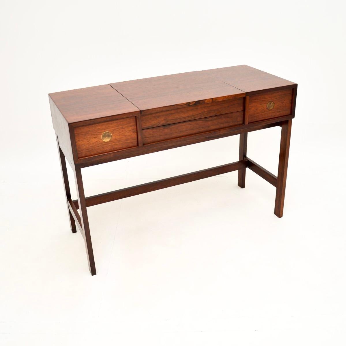 A beautiful Danish vintage dressing table and stool by Dyrlund. They were made in Denmark, and date from around the 1960-70’s.

The quality is amazing, the table has a fantastic design where the centre section flips up to reveal a mirror and storage