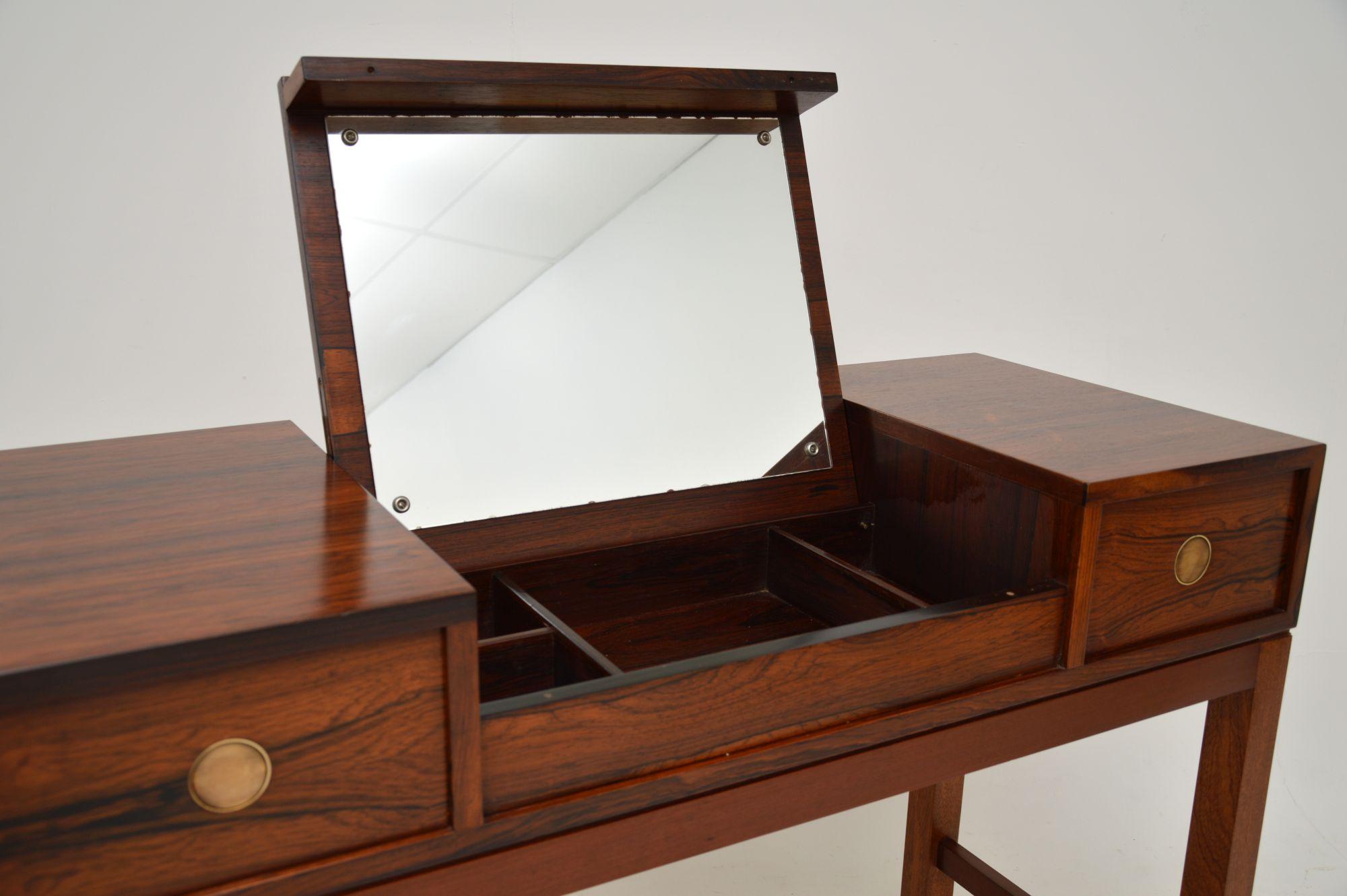 A beautiful Danish vintage dressing table by Dyrlund. This was made in Denmark and dates from around the 1960-70’s.

The quality is amazing, this has a fantastic design where the centre section flips up to reveal a mirror and storage compartments.