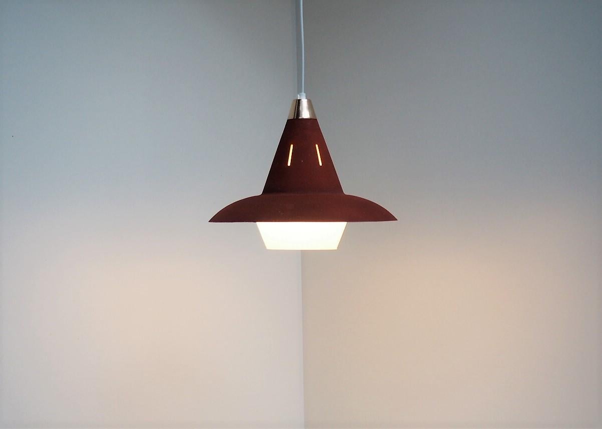 Danish vintage pendant made in red painted metal and a white decorative glass shade to cover for the bulb. At the top there is a new polished brass decoration. It´s made during the 1940´s and most likely by eighter Fog & Mørup or Lyfa. 
The red