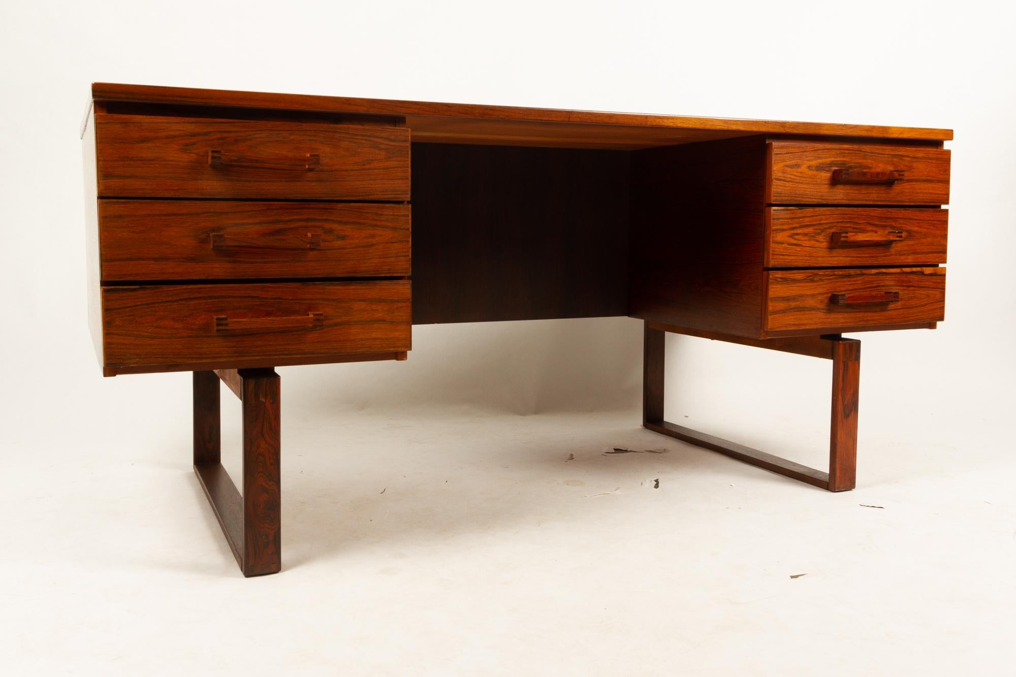 Danish vintage rosewood desk by Henning Jensen & Torben Valeur for Munch Møbler, 1960s
Large executive desk in beautiful vivid rosewood veneer. Two drawer sections with three drawers each. Back with one long open shelf. Large and deep work surface