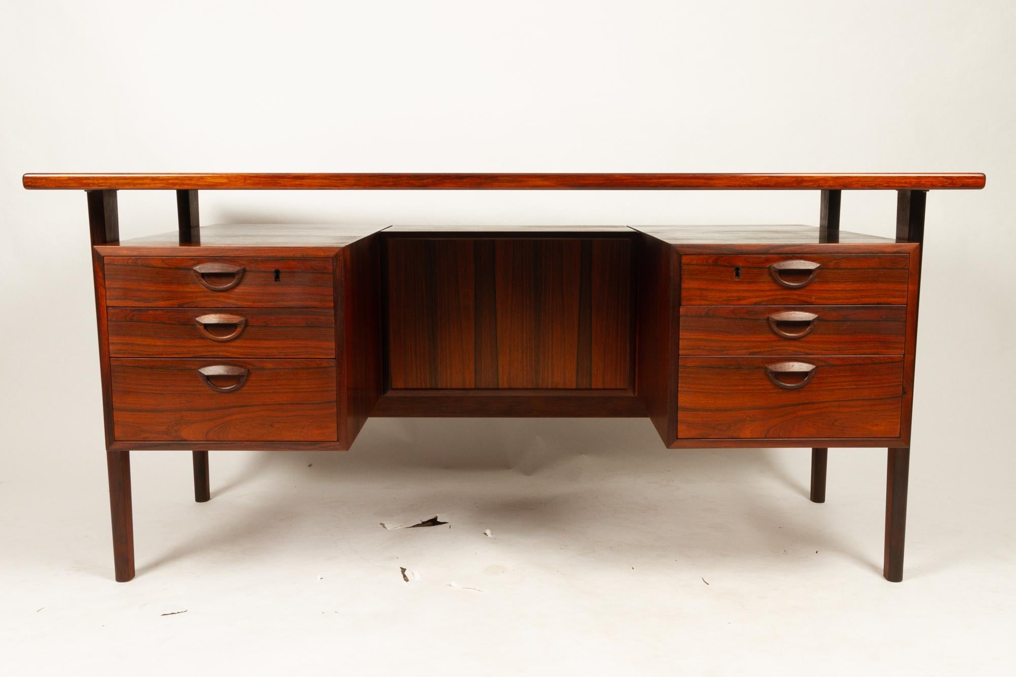 Danish vintage rosewood desk by Kai Kristiansen for Feldballe Møbelfabrik, 1960s.
The classic and iconic Model FM 60 executive desk in Rosewood by Danish designer Kai Kristiansen.
Freestanding desk with floating desktop. Two drawer sections with