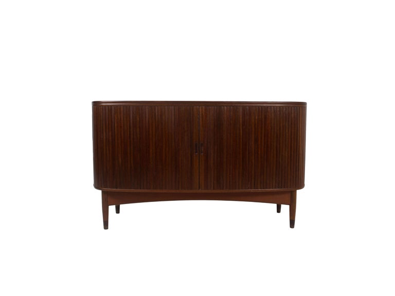 Charming Danish Vintage Sideboard with Tambour Doors in Teak Veneer from the 1950s. This vintage sideboard has a front and side with two tambour doors. Behind the doors, there are shelves and drawers that are all extendable and have a curved shape