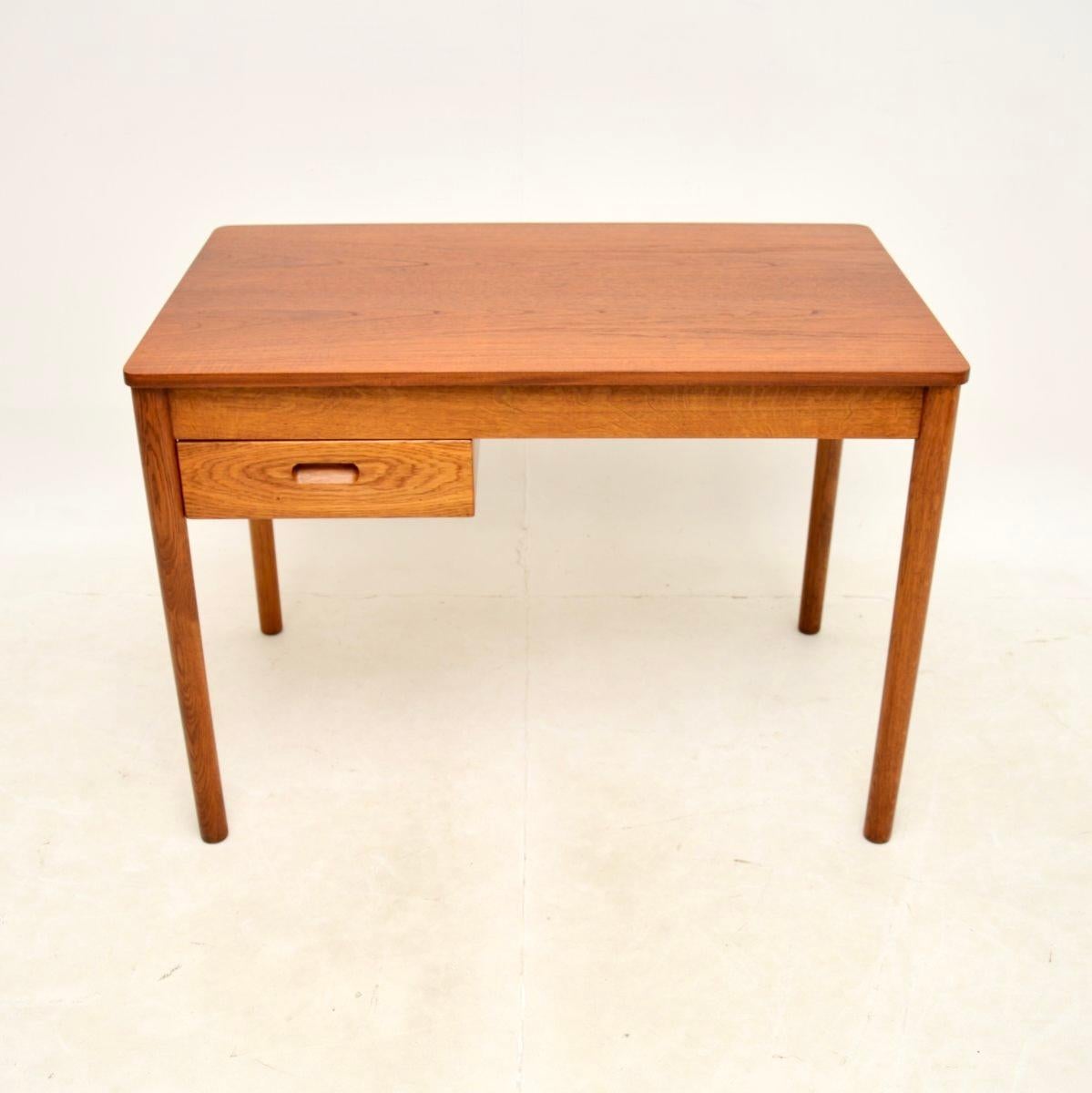A smart and extremely well made Danish vintage teak and oak desk, dating from the 1960’s.

This is of superb quality and is a lovely, compact size. It is made almost completely of solid oak, with a beautiful teak top. There is a single deep drawer