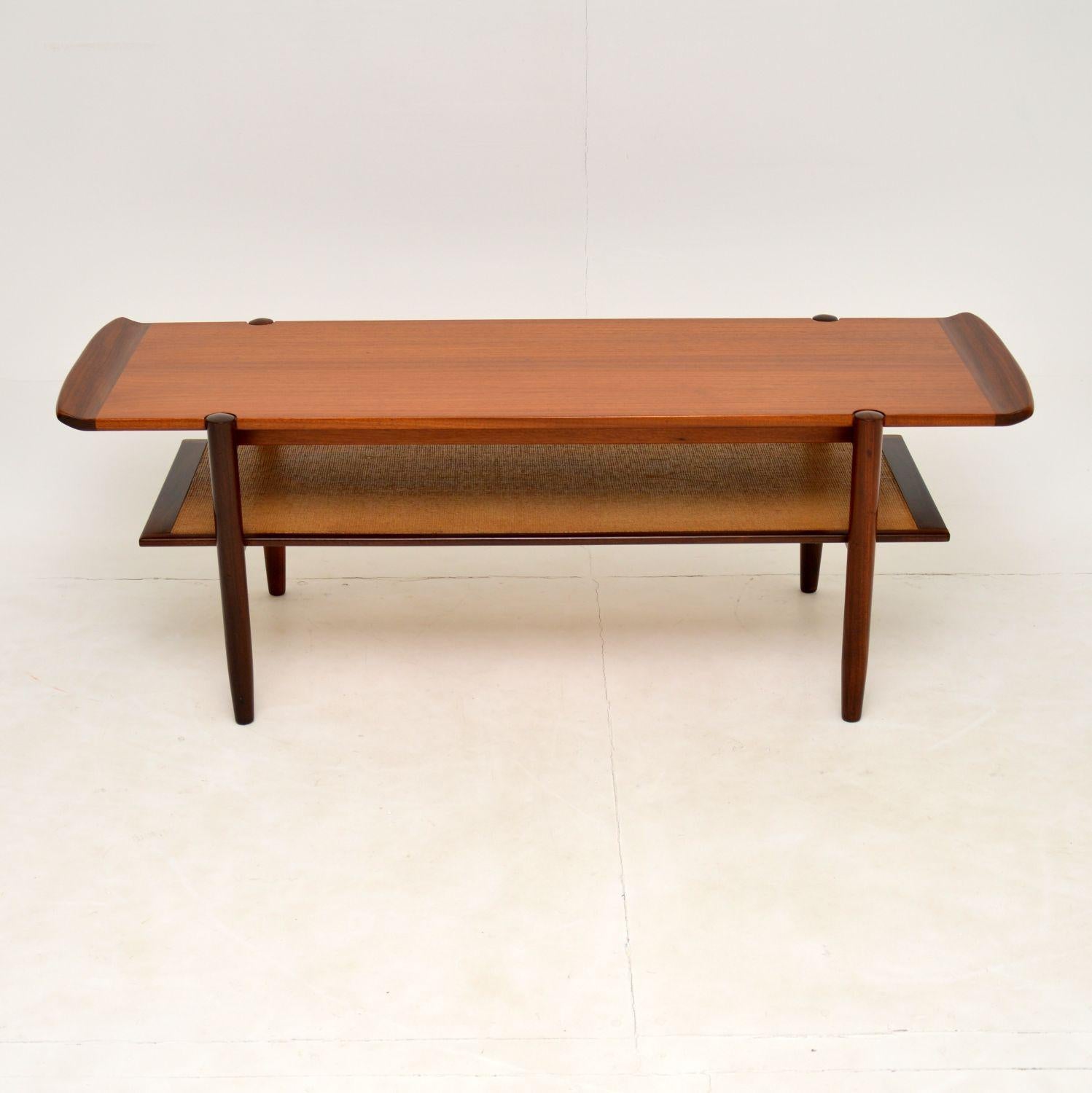 A large and very impressive vintage teak two tier coffee table. This was made in Denmark, it dates from the 1960’s.

The quality is amazing, this has solid afromosia legs and upturned ends, that contrast nicely with the teak. The lower tier is