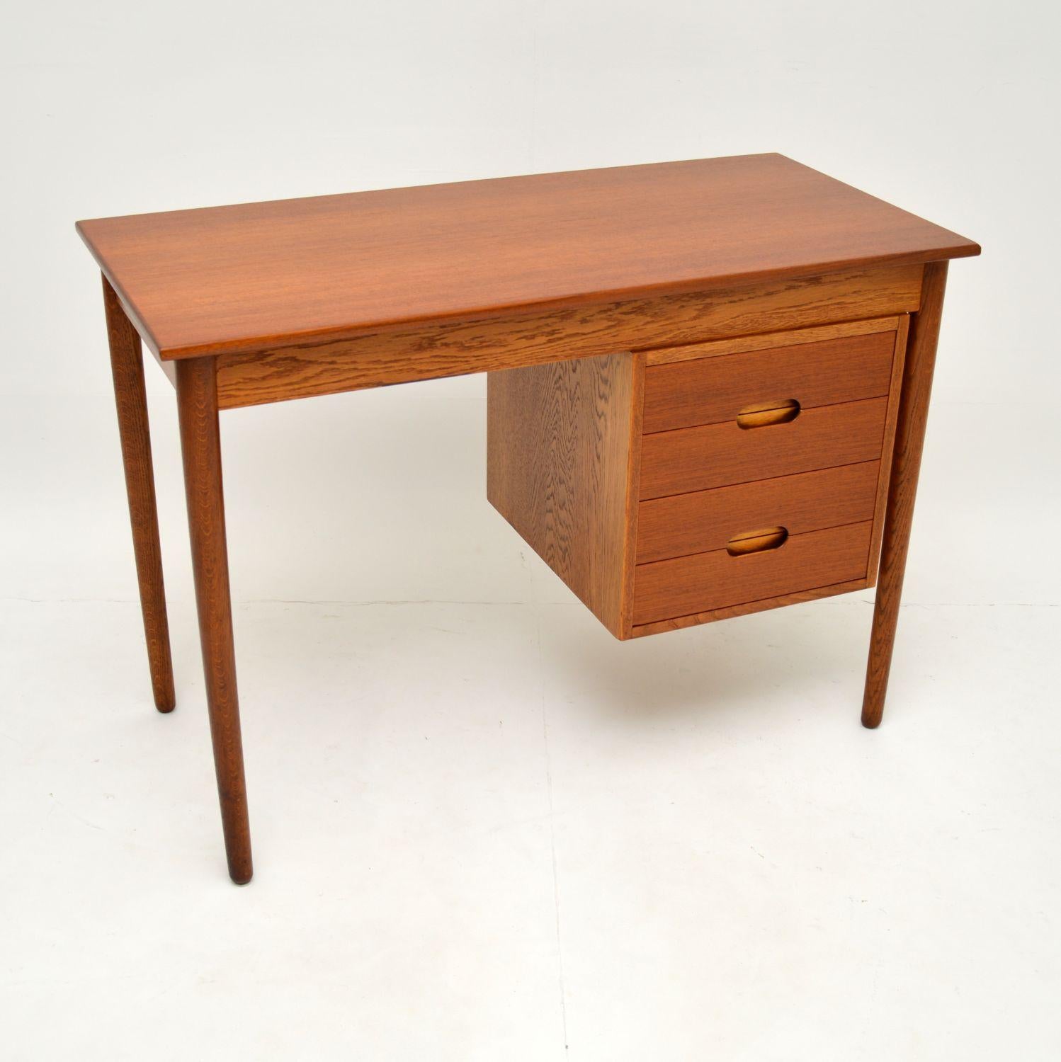 A stunning and extremely rare vintage Danish desk. This was made in Denmark by Jutex, it was designed by Arne Hovmand-Olsen.

It is beautifully made with a solid oak carcass and gorgeous teak veneers. The drawer fronts have lovely recessed