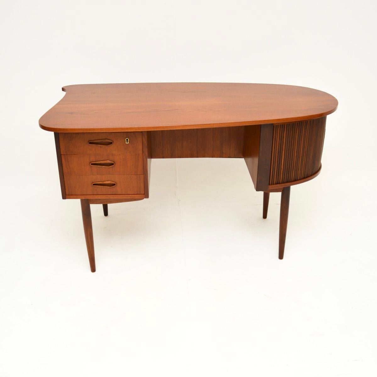 Ein sehr stilvoller und sehr gut gemachter dänischer Vintage-Schreibtisch aus Teakholz, der aus den 1960er Jahren stammt.

Es ist von erstaunlicher Qualität und hat ein unglaubliches Design. Die Platte hat eine asymmetrische Form, auf einer Seite