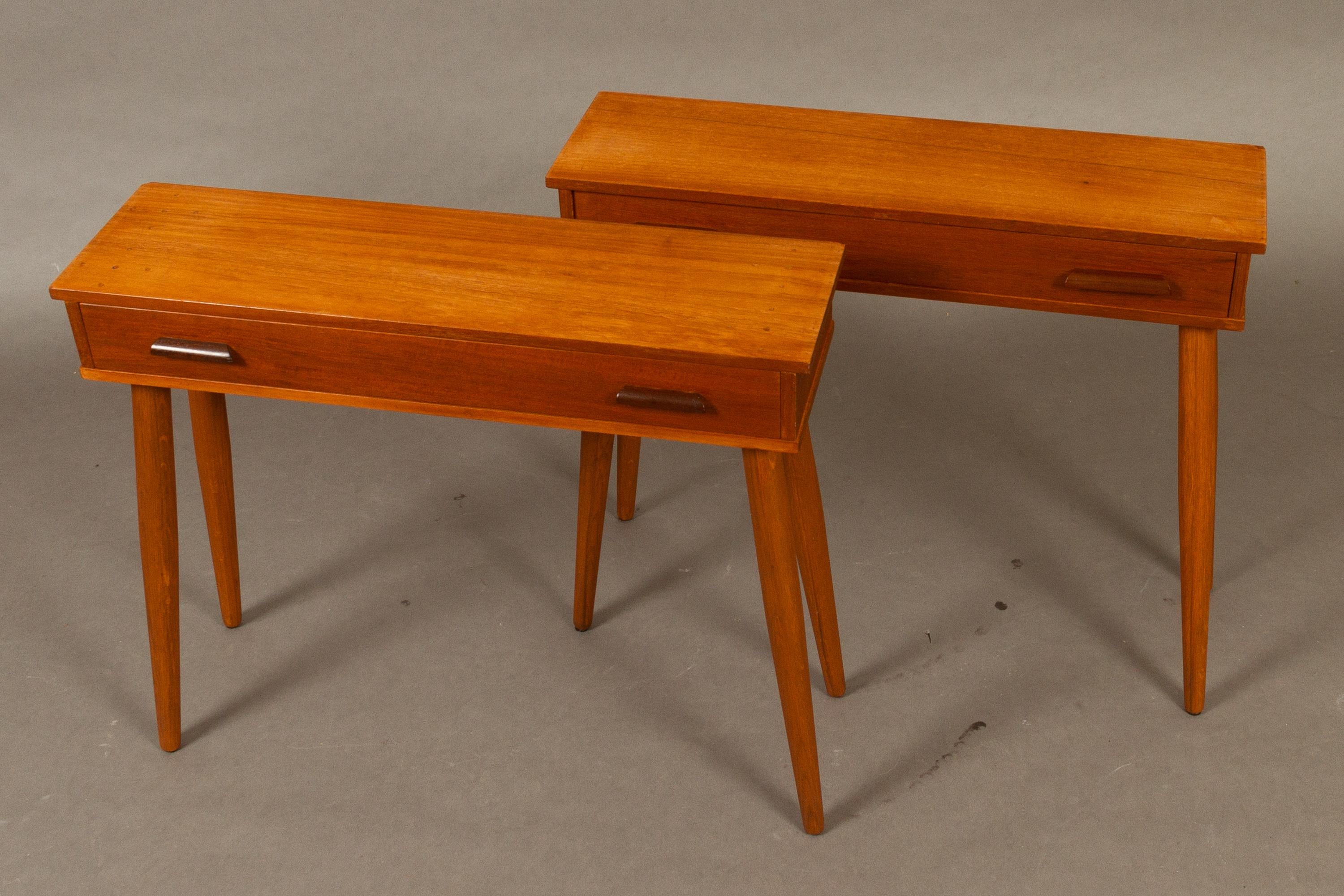 Danish Vintage Teak Night Stands 1960s Set of 2.
Pair of matching bedside tables with wide drawer. Long round tapered legs (not original!) Also suitable as console or side tables.
Veneer on top has several marks and small holes, some damage to