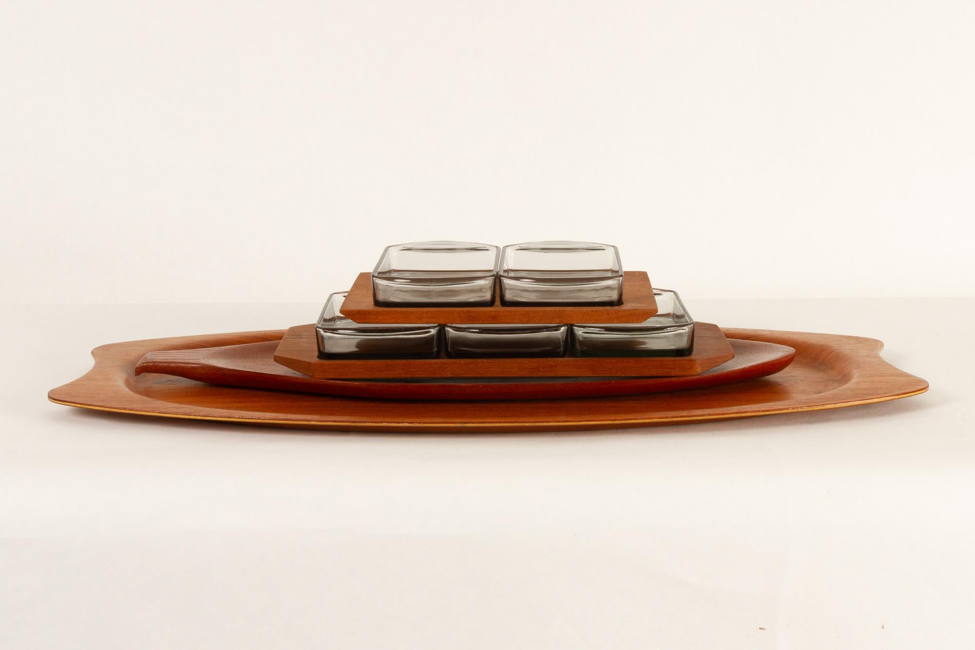 Danish vintage teak serving trays 1960s set of 4.
Danish Mid-Century Modern teak trays.
This set consists of:
A large oval tray by Silva, length 65.5.
A leaf shaped tray in solid teak.
Two serving trays with glass bowls by Wiggers.
Good