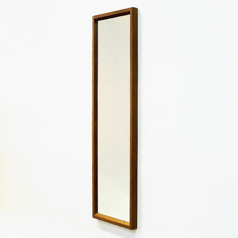 Danish oak wall mirror of by designer Aksel Kjersgaard, Denmark. 1960's. Marked on the backside with Aksel Kjersgaard, Odder and Made in Denmark. Numbered No 114. This mirror is of a great quality in construction and has great details, such as the
