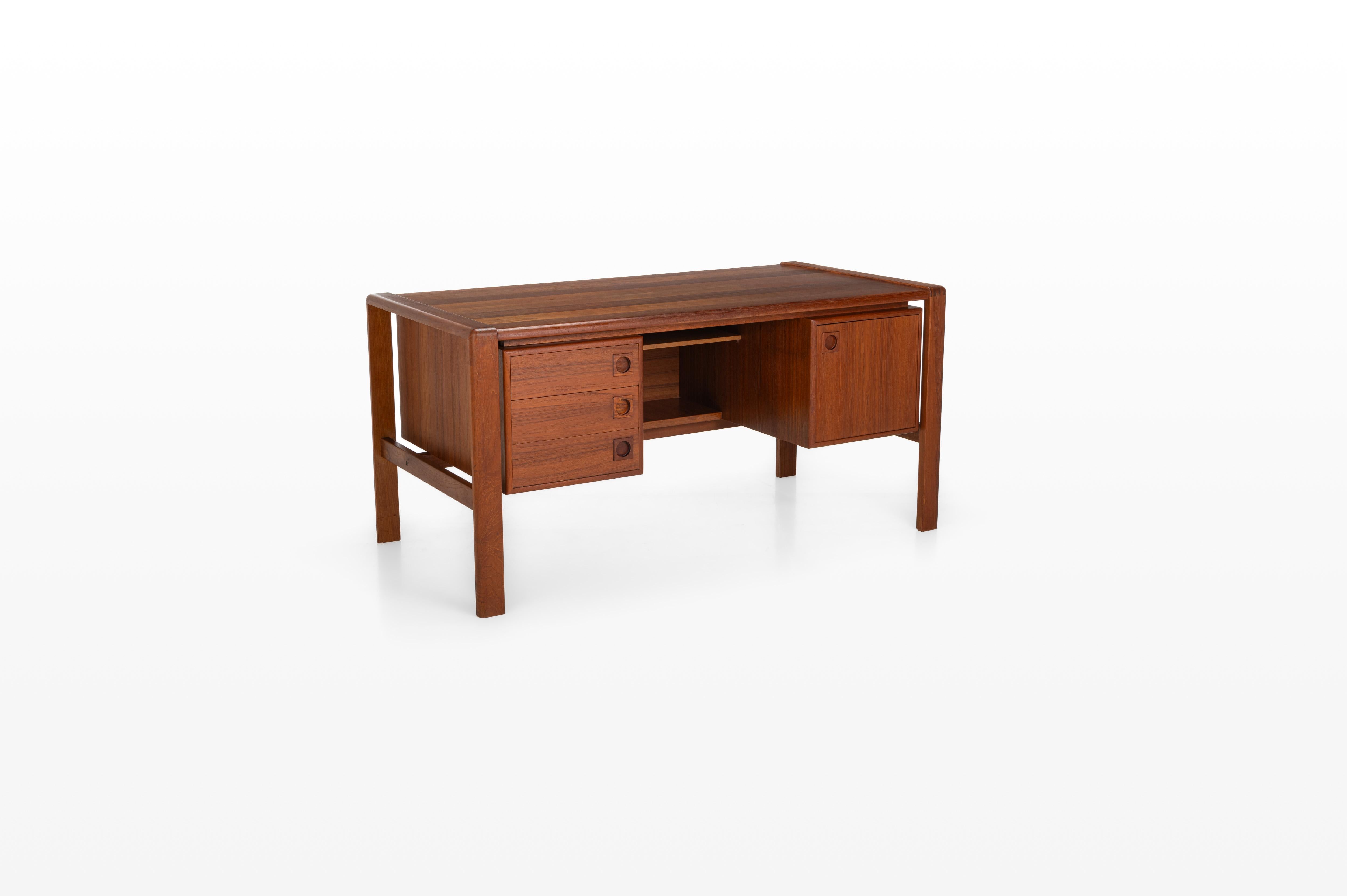 This vintage writing desk, crafted by HP Hansen in 1960s Denmark, is made from teak wood and has very nice details. It features three drawers, a storage cabinet, and additional open storage space at the back. This writing desk is in great