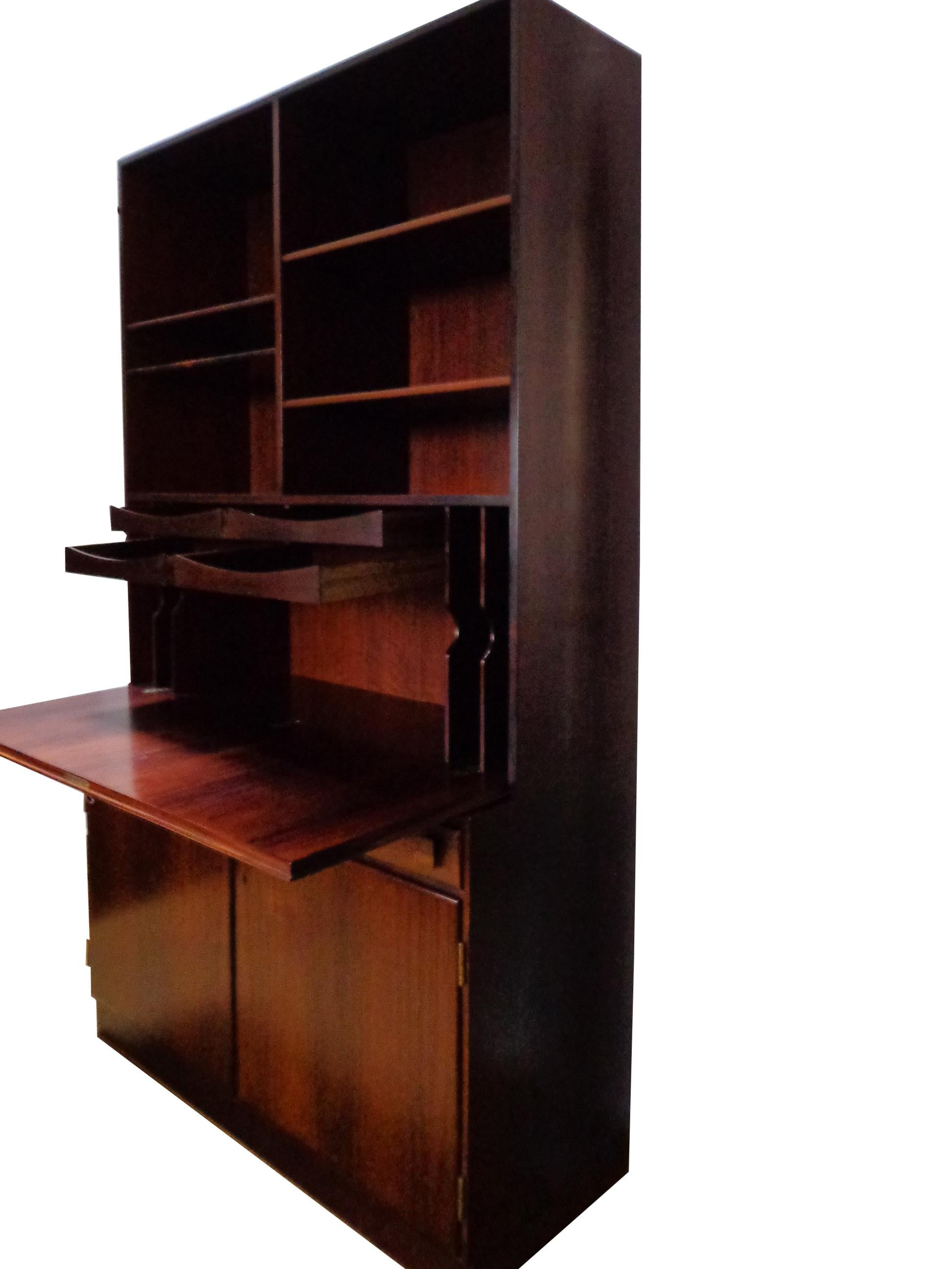 Offered by Zitzo, Amsterdam: Wall unit of rosewood designed by Takashi Okamura and Erik Marquardsen, consisting base cabinet with doors and shelves inside. Top cabinet with pullout trays, shelves and drop leaf-desk. Original keys