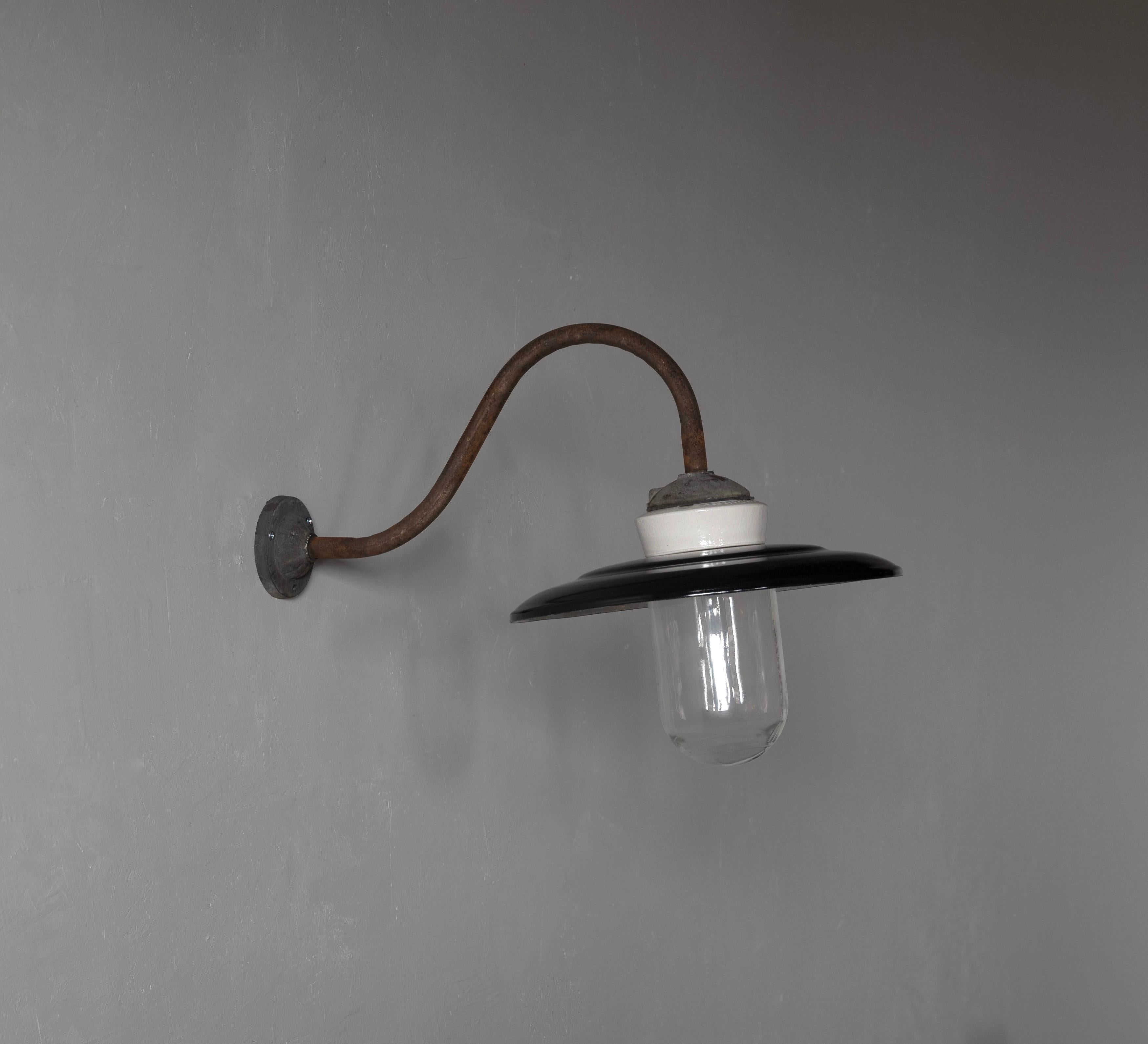 A pair wall light. Designed and produced in Denmark, c. 1930s-1940s. Features iron, porcelain black-lacquered metal, glass

Fixture presents with dramatic and beautiful patina.

Three arm brass wall light with frost glass. Engraved on the front of