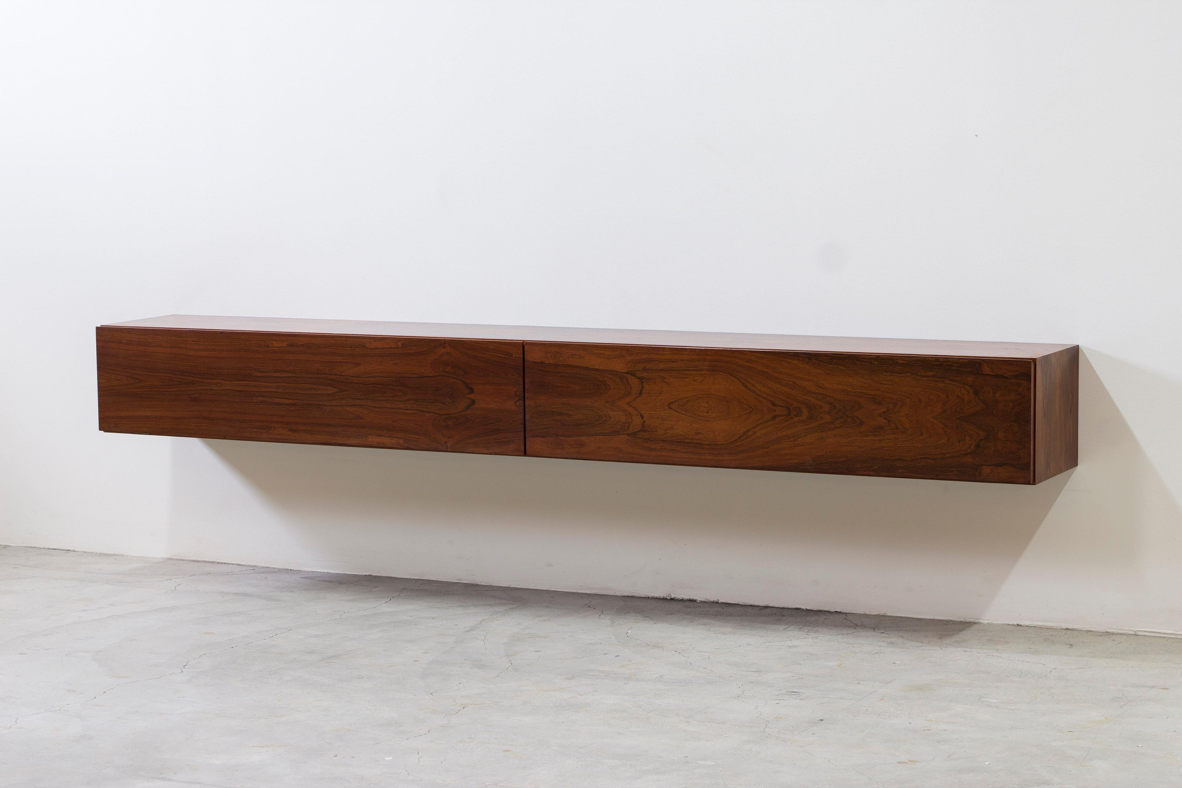 Wall mounted sideboards designed and made in Denmark during the 1960s. Made from palisander wood with very richly figured grain. Matching veneers on the doors and top of the sideboard. The sideboards are easily installed on the wall with screws and