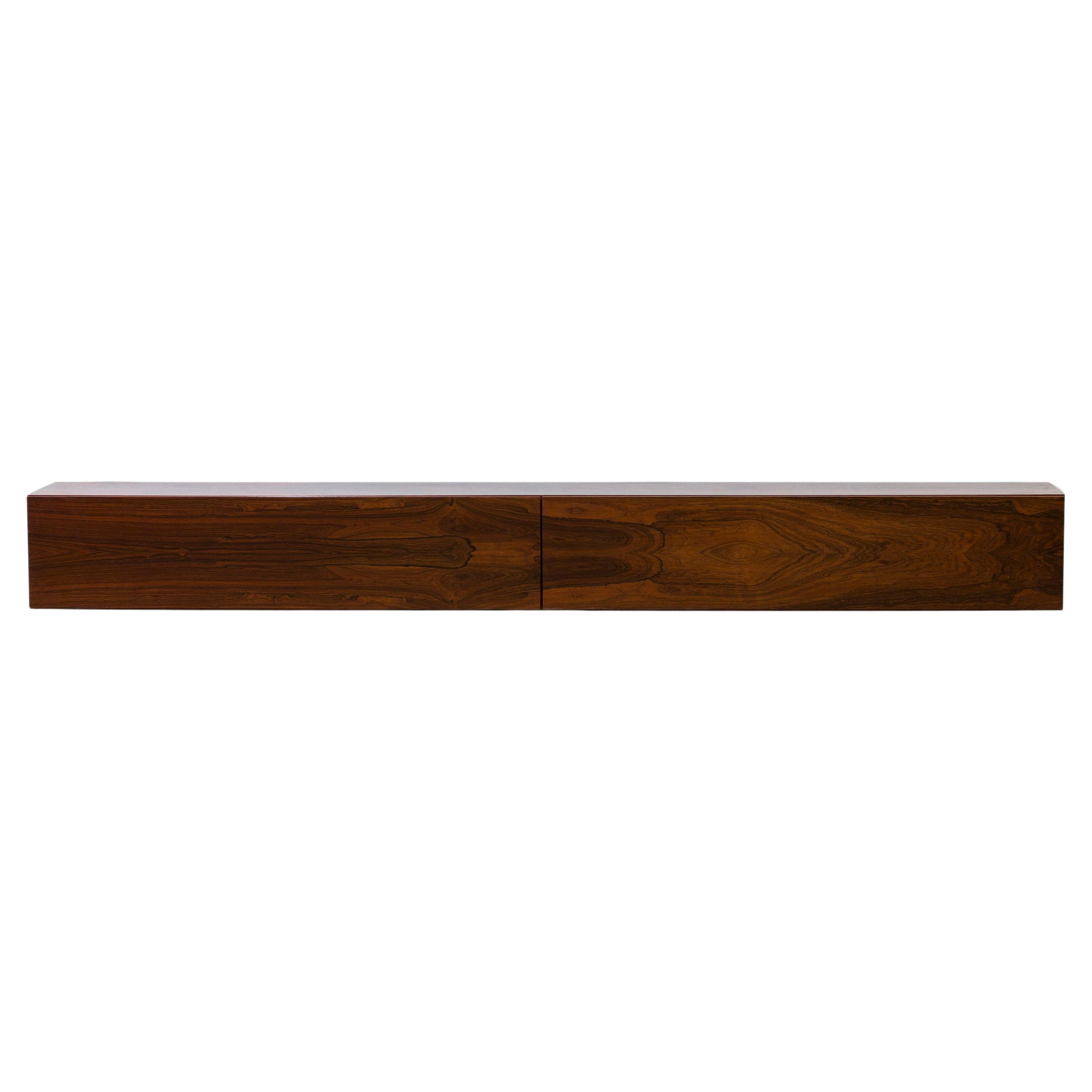 Wall mounted sideboards designed and made in Denmark during the 1960s. Made from palisander wood with very richly figured grain. Matching veneers on the doors and top of the sideboard. The sideboards are easily installed on the wall with screws and