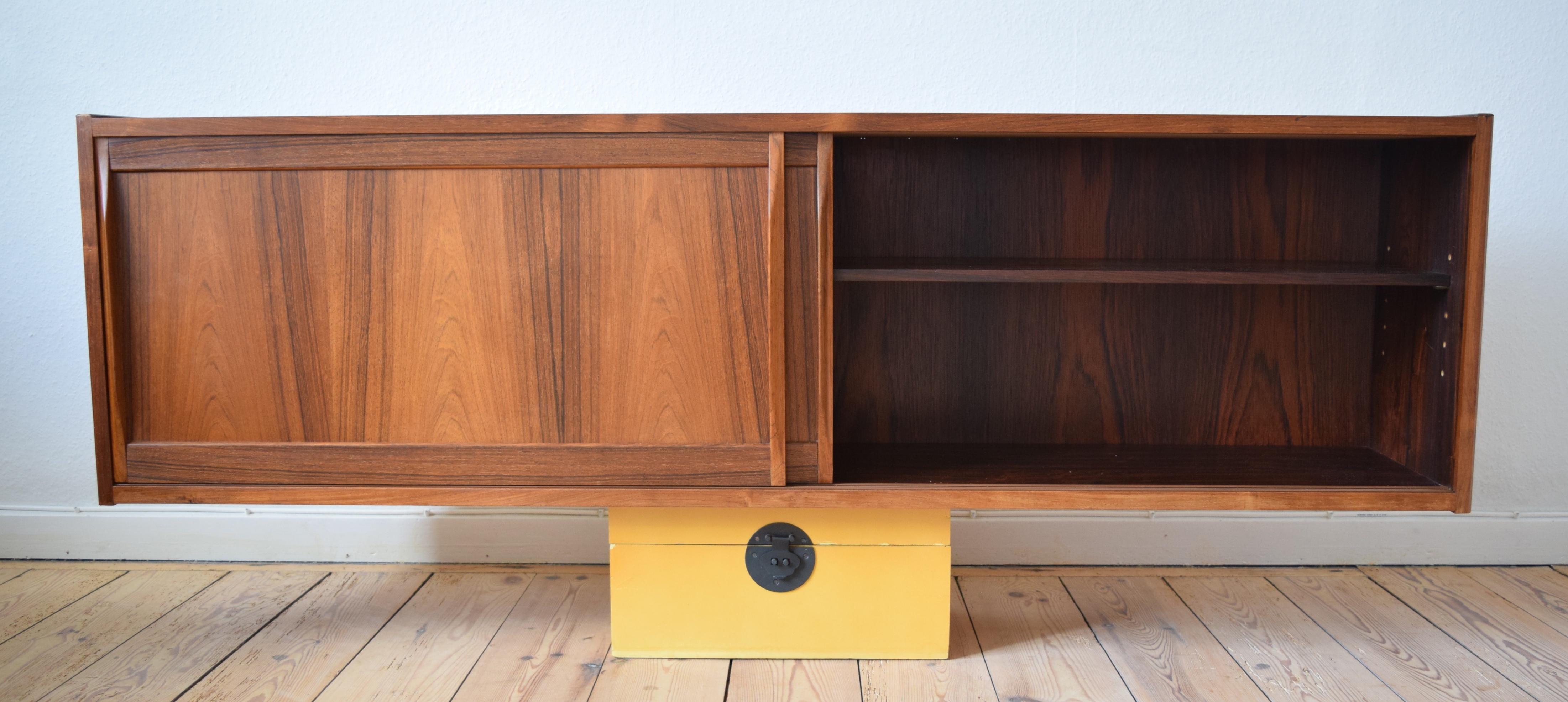 Rosewood wall-mounted sideboard manufactured in Denmark by Klim Møbelfabrik and designed by Erling Torvits in the 1960s. Features two smooth sliding doors with solid rosewood handles, Adjustable interior shelves. Stunning wood grain inside and